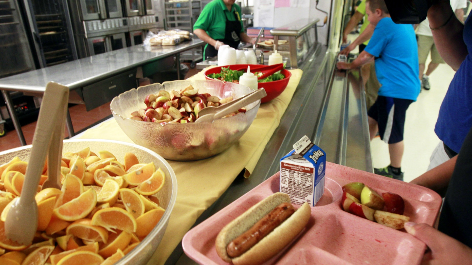 Students pick up their lunch at Barre Town Elementary School in Barre Town, Vt. The Agriculture Department said Friday, Jan. 3, 2013, it’s making permanent rules that allow schools to serve larger portions of lean meat and whole grains in school lunches and other meals.