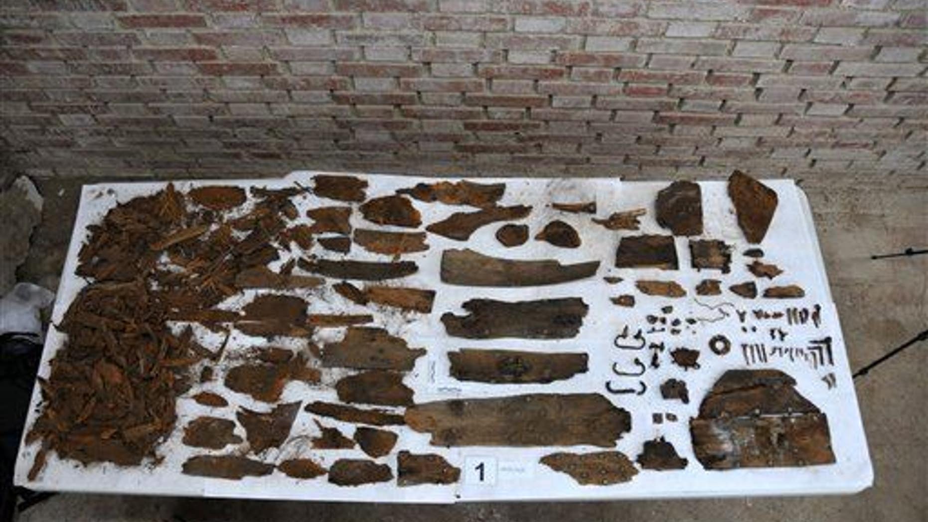 This photo taken on Saturday, Jan. 24, 2015 and provided by Aranzadi Science Society, shows the initials "M.C" on a plank, right, and remains of a coffin.