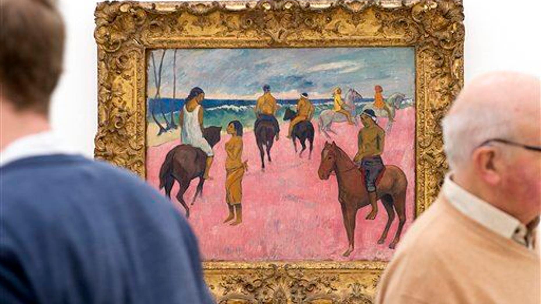 Two men stand next to "Cavaliers sur la plage" (Riders on the beach, 1902) by French painter Paul Gauguin at an exhibition in the Fondation Beyeler in Riehen, Switzerland, on Friday, Feb. 6, 2015.