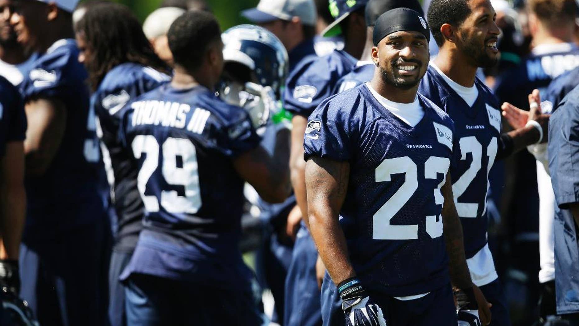 Seattle Seahawks strong safety Jeron Johnson (23) stands with teammates as the huddle breaks up following a session of NFL football training camp, Tuesday, Aug. 5, 2014, in Renton, Wash. (AP Photo/Ted S. Warren)