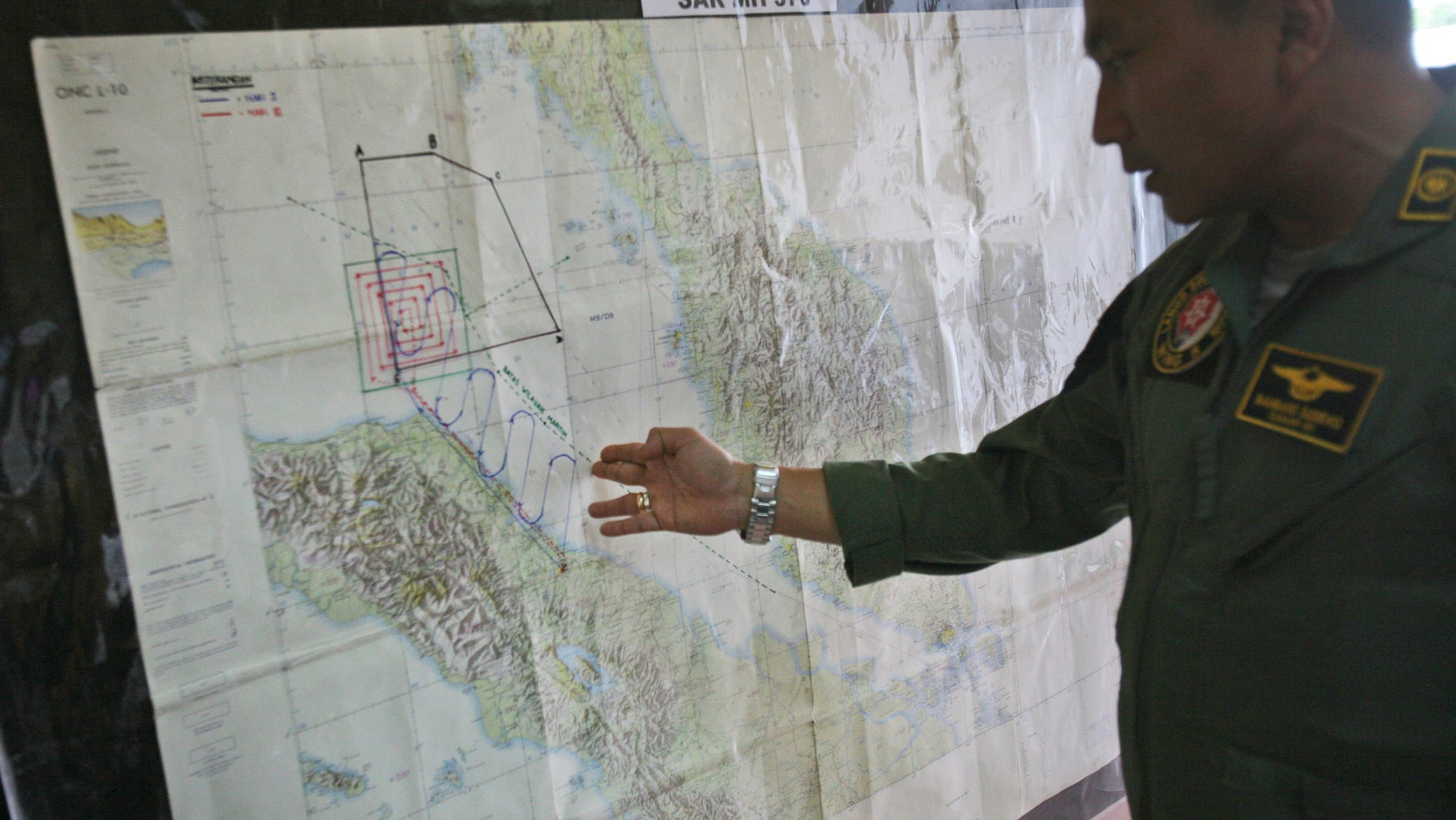 Lt. Col Bambang Sudewo, commander of the 5th Air Squadron "Black Mermaids" examines a map following a search operation for the missing Malaysia Airlines Boeing 777 that was conducted over the Strait of Malacca, at Suwondo air base in Medan, North Sumatra, Indonesia, Friday, March 14, 2014. The jetliner vanished nearly a week ago with 239 people aboard. (AP Photo/Binsar Bakkara)