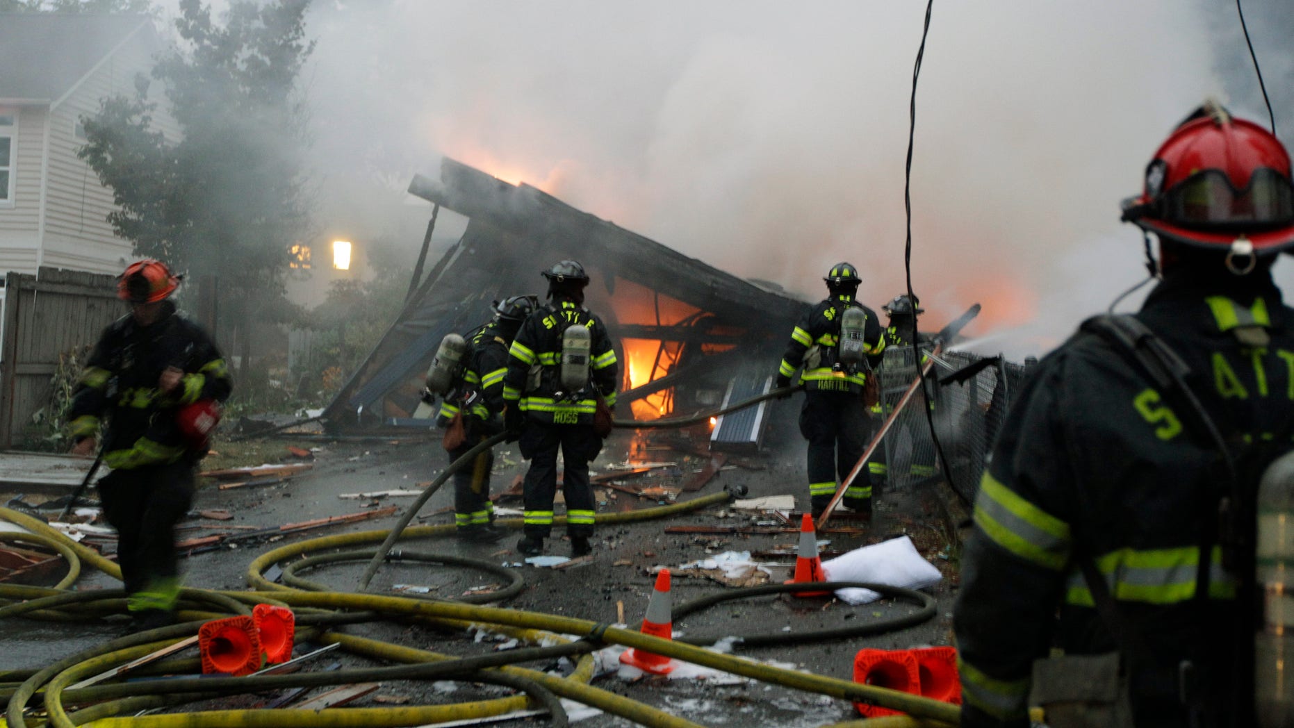 September 26: Seattle firefighters work to extinguish a fire at a home in Seattle following a large explosion. Two people were injured, one with life-threatening injuries and the other is in serious condition.