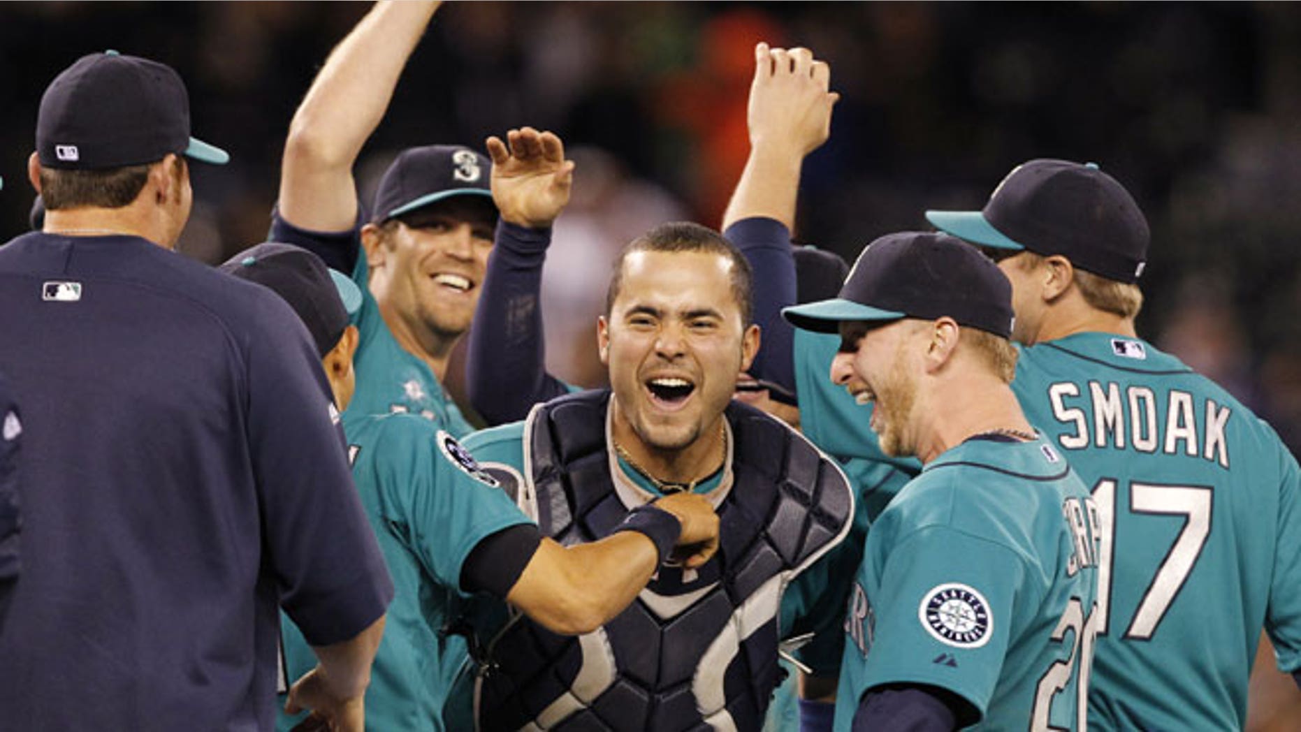 June 8, 2012: Seattle Mariners catcher Jesus Montero, center, celebrates with teammates, including closer Tom Wilhelmsen, left, after the final out against the Los Angeles Dodgers in a baseball game in Seattle.
