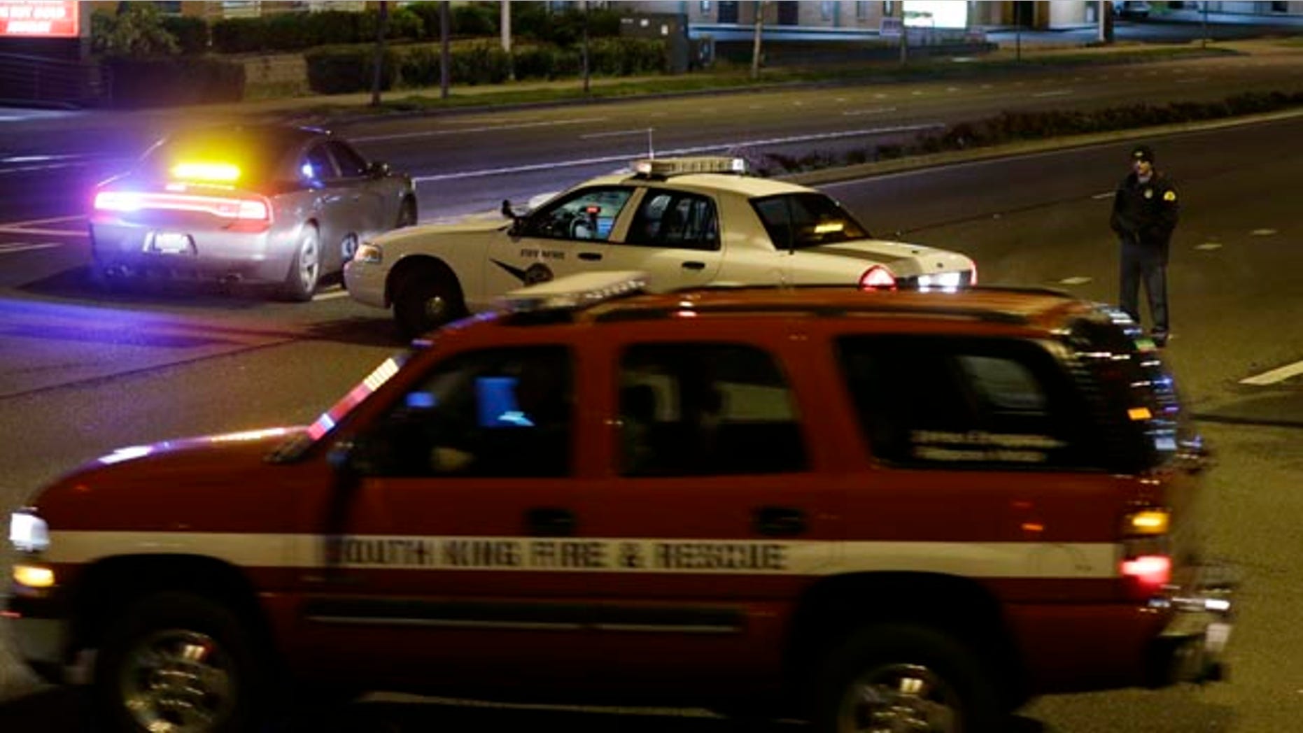April 22, 2013: A Washington State Patrol trooper directs a driver away from a street blocked off several blocks from the scene of an overnight shooting that police said left five people dead.
