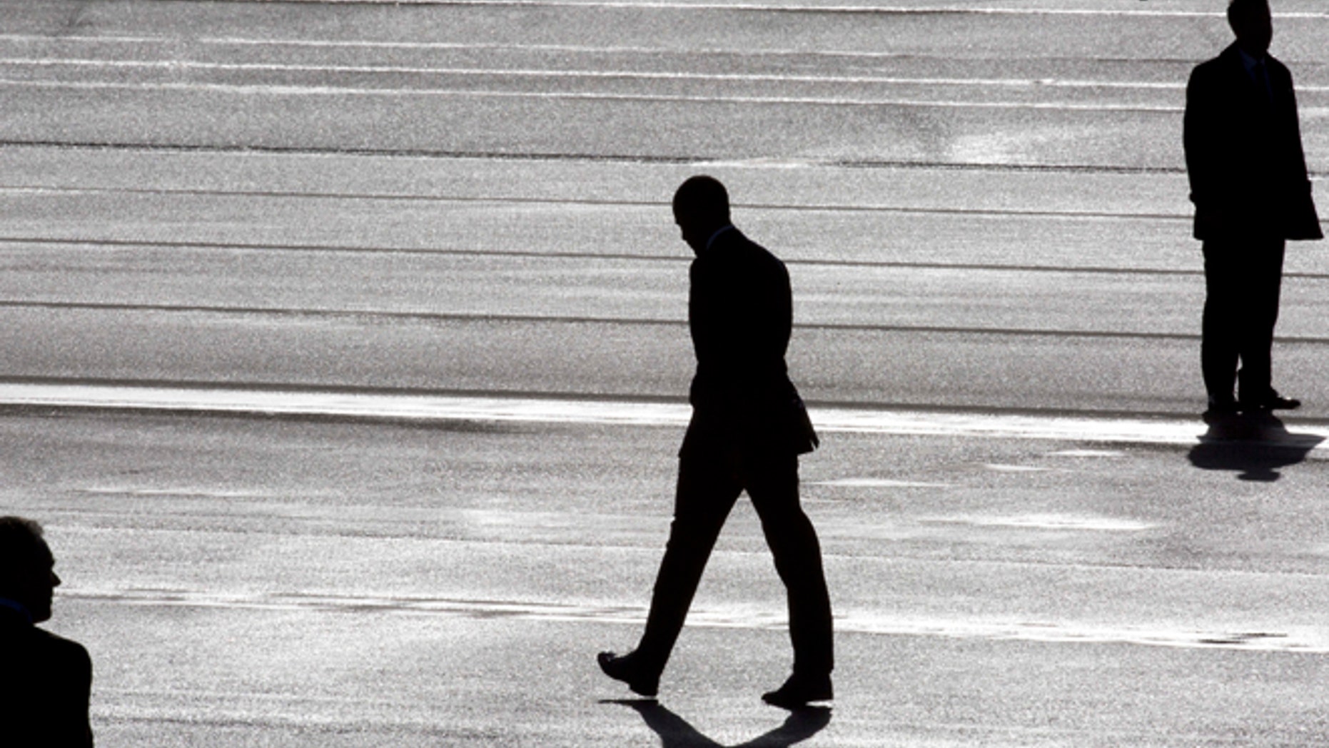 President Barack Obama, center, and two secret service agents are silhouetted as he walks towards Marine One helicopter upon arrival at Schiphol Amsterdam Airport, Netherlands, Monday March 24, 2014. Obama will attend the two-day Nuclear Security Summit in The Hague. (AP Photo/Peter Dejong, POOL)