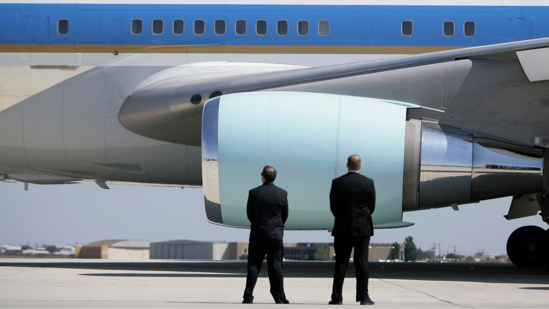 In this Saturday, Oct. 4, 2008 photo, Secret Service agents watch as Air Force One departs Midland International Airport with President Bush and first lady Laura Bush aboard in Midland, Texas. (AP Photo/Matt Slocum)