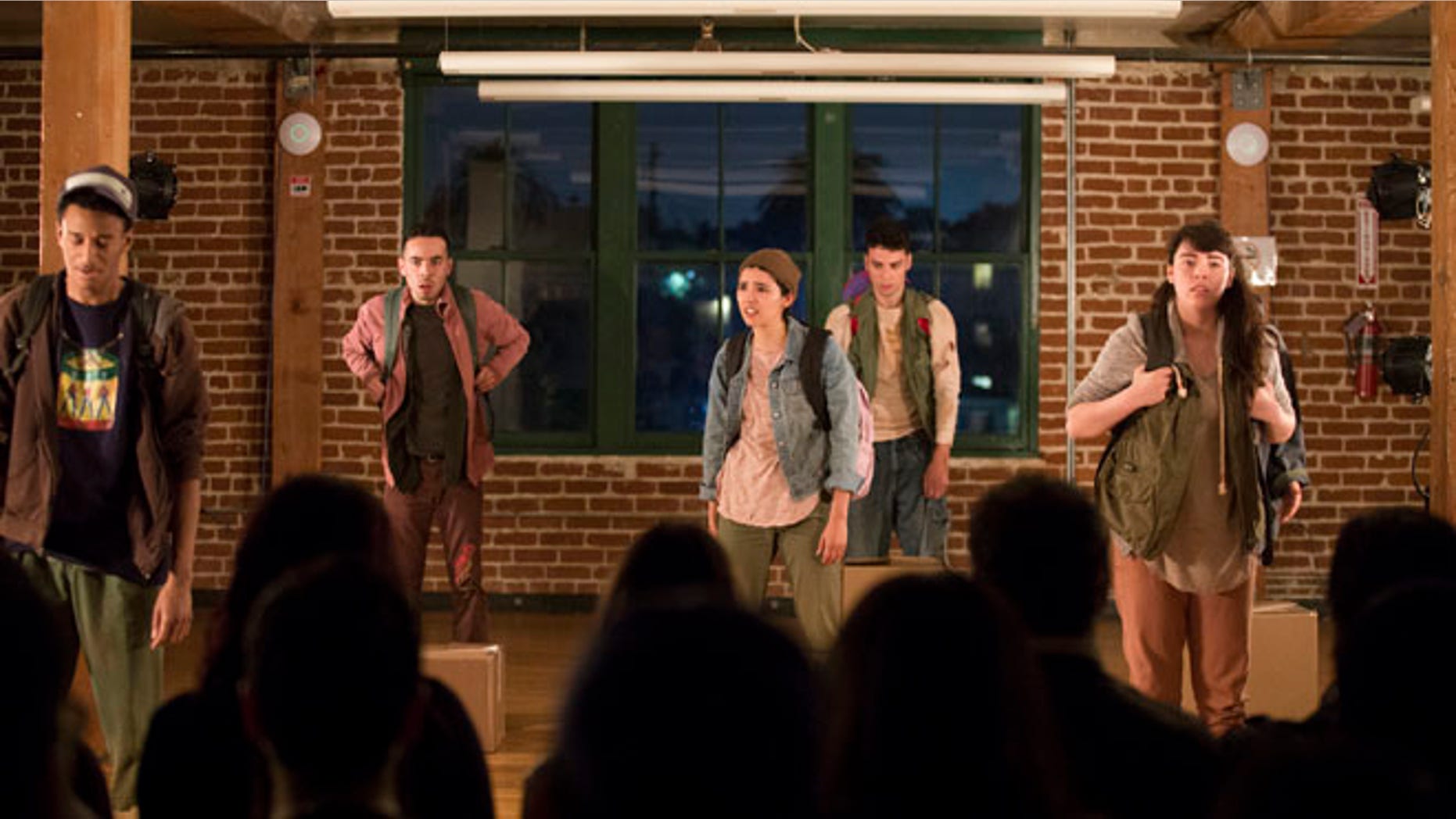 In this Friday, March 18, 2016 photo, from left, actors Julien Moore, Julian Sandoval, Cynthia Callejas, Peter Mark and Audrey Olmos perform in the play "Shelter" at CalArts Center for New Performance in Los Angeles. For Sandoval, the play "Shelter" is more than just a story of children flooding into the U.S. by the tens of thousands from Latin America in search of safe sanctuary. It's personal. The young actor's mother immigrated to the U.S. illegally years ago, fleeing the violence of her native El Salvador after seeing a cousin hacked to death by soldiers with machetes during the country's civil war. She would become a legal resident under the Immigration Reform and Control Act of 1986 and eventually a U.S. citizen. (AP Photo/ Jenna Schoenefeld)