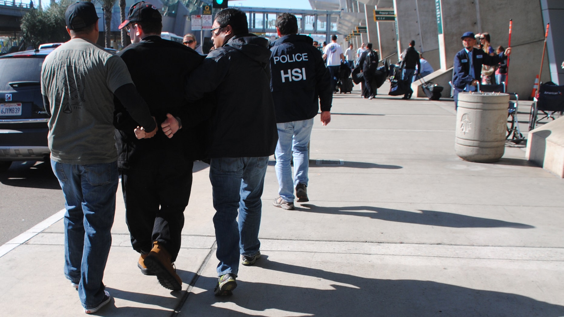 In this Friday, Jan. 29, 2016 photo provided by the U.S. Immigration and Customs Enforcement (ICE), former Columbus, Ohio, seminarian Joel Wright, second left, is arrested at San Diegos airport in San Diego on federal charges for allegedly seeking to have sex with infant and young girls in Mexico. (U.S. Immigration and Customs Enforcement via AP)