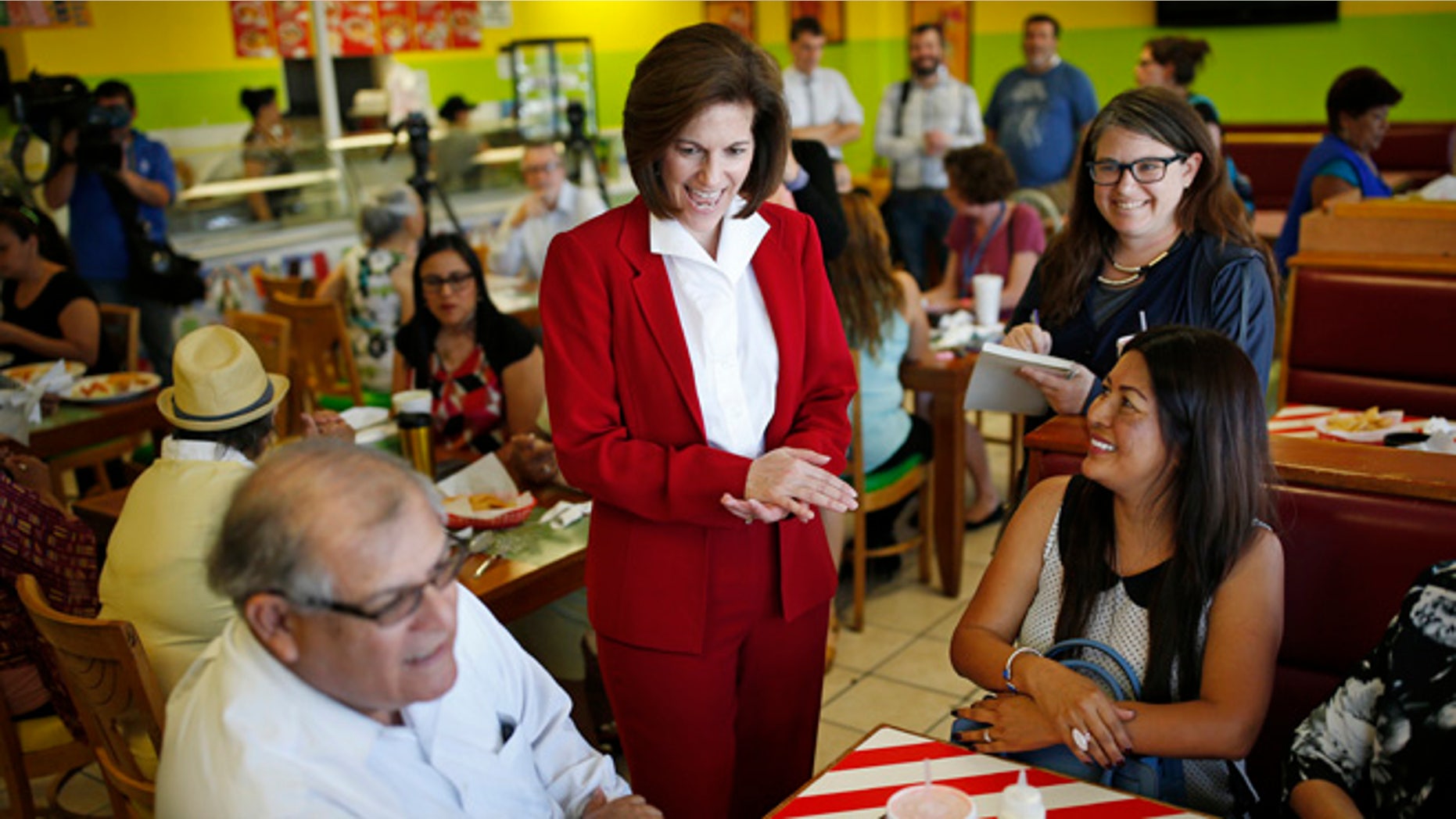 In this May 31, 2016, photo, U.S. Senate candidate Catherine Cortez Masto, center, laughs while speaking with people at a campaign event at a restaurant in Las Vegas. A battle royal is shaping up in Nevada over the open Senate seat created by the retirement of Minority Leader Harry Reid of Nevada. A former state attorney general, Masto, would be the first Latina ever to serve in the U.S. Senate. (AP Photo/John Locher)