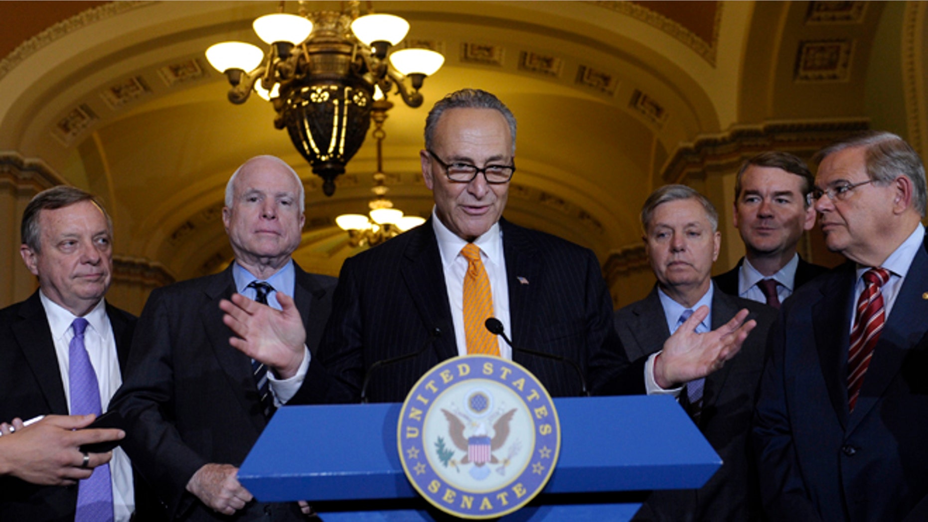 Sen. Charles Schumer, D-N.Y., center, speaks following a vote in the Senate on immigration reform on Capitol Hill in Washington, Thursday, June 27, 2013. (AP Photo/Susan Walsh)