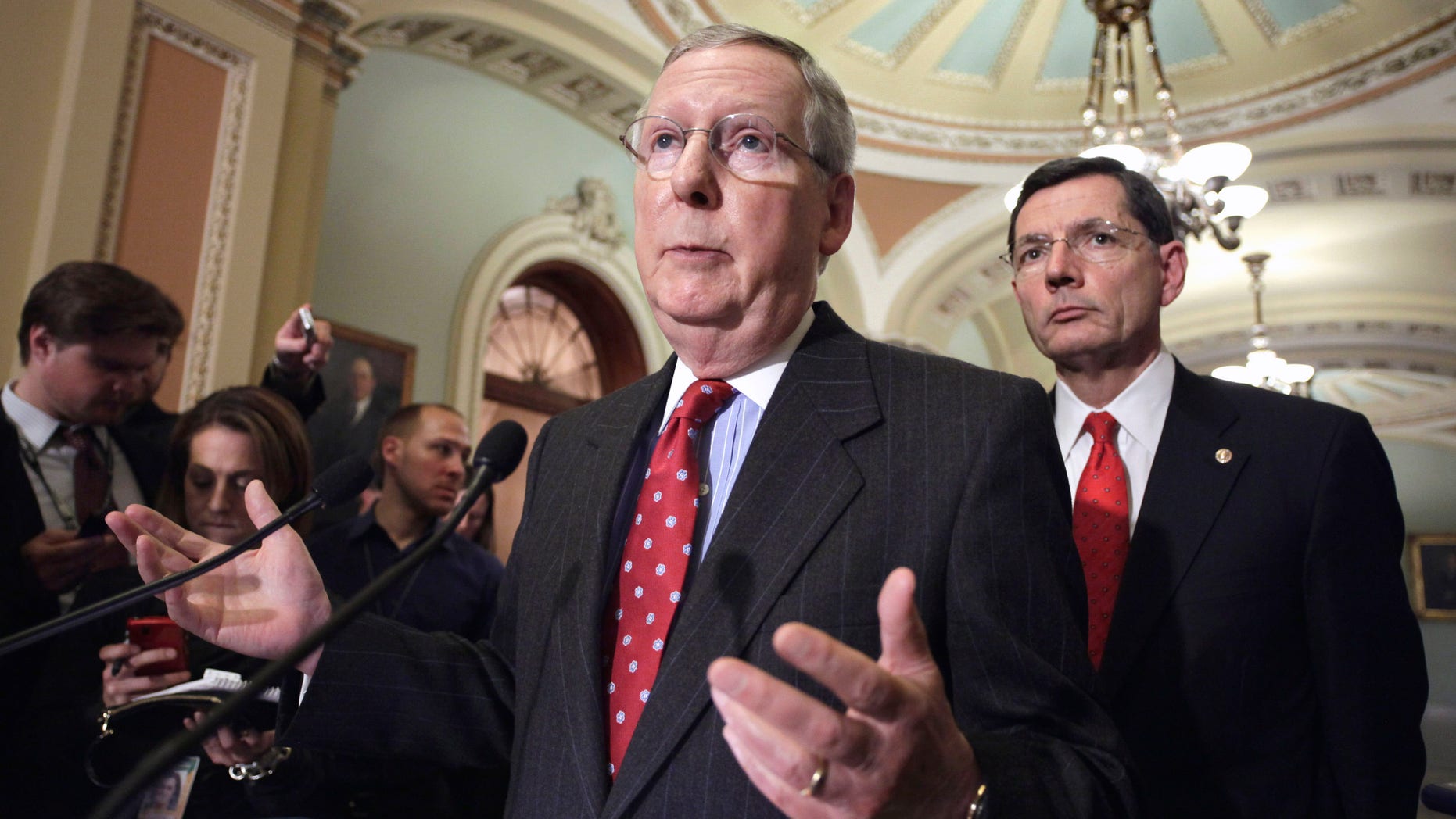 Senate Minority Leader, Mitch McConnell of Ky., left, accompanied by Sen. John Barrasso, R-Wyo., speaks with reporters on Capitol Hill. McConnell said March. 16 that while he'll support a three-week temporary spending measure in a vote this week, the $500 billion-plus Pentagon budget should not be subject to weekly renewal.