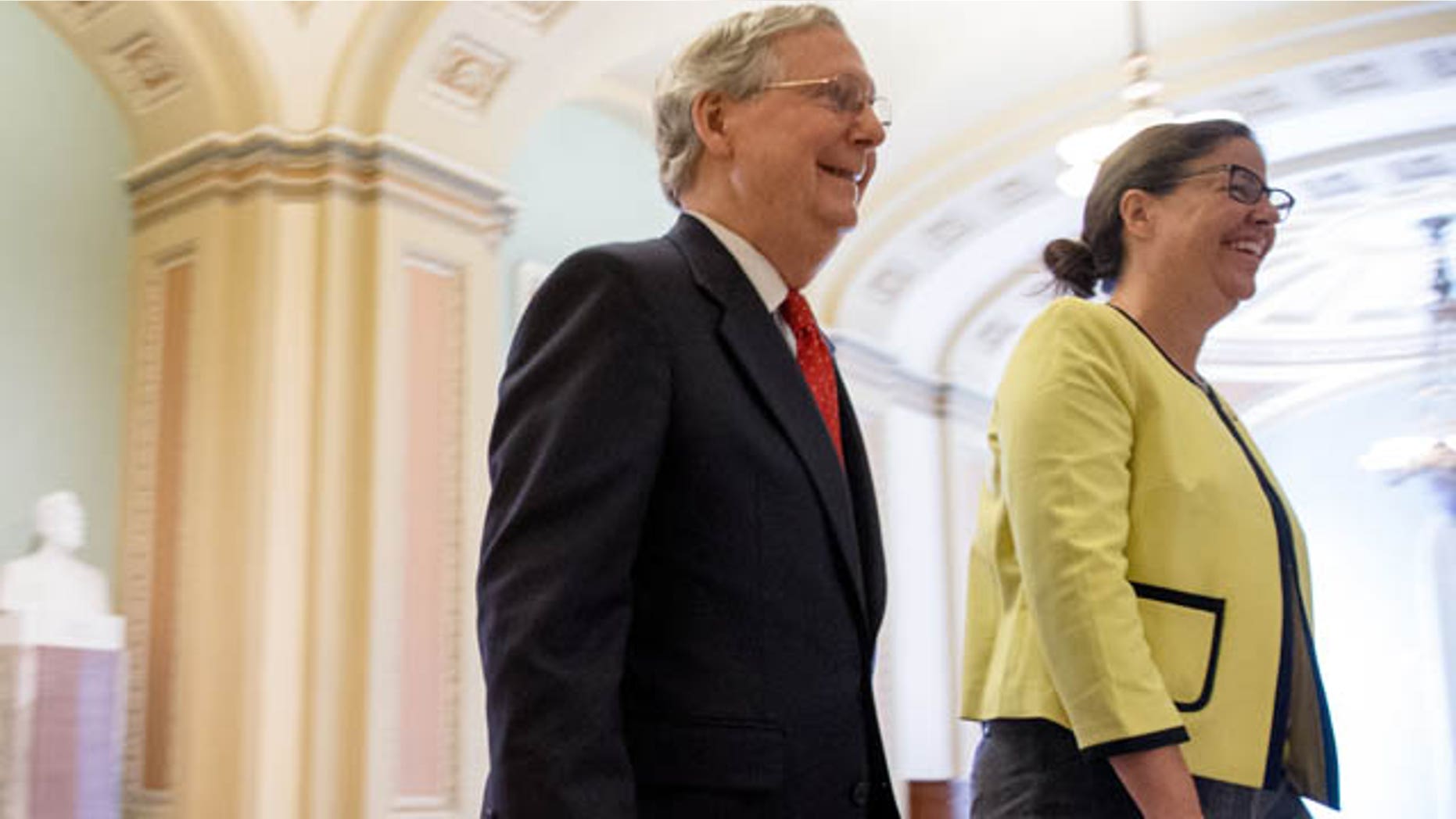 July 26, 2015: Senate Majority Leader Mitch McConnell, R-Ky., left, accompanied by Secretary for the Majority of the Senate Laura Dove, heads into the Senate chamber as the Senate convenes for a Sunday session on Capitol Hill in Washington. (AP Photo/Andrew Harnik)