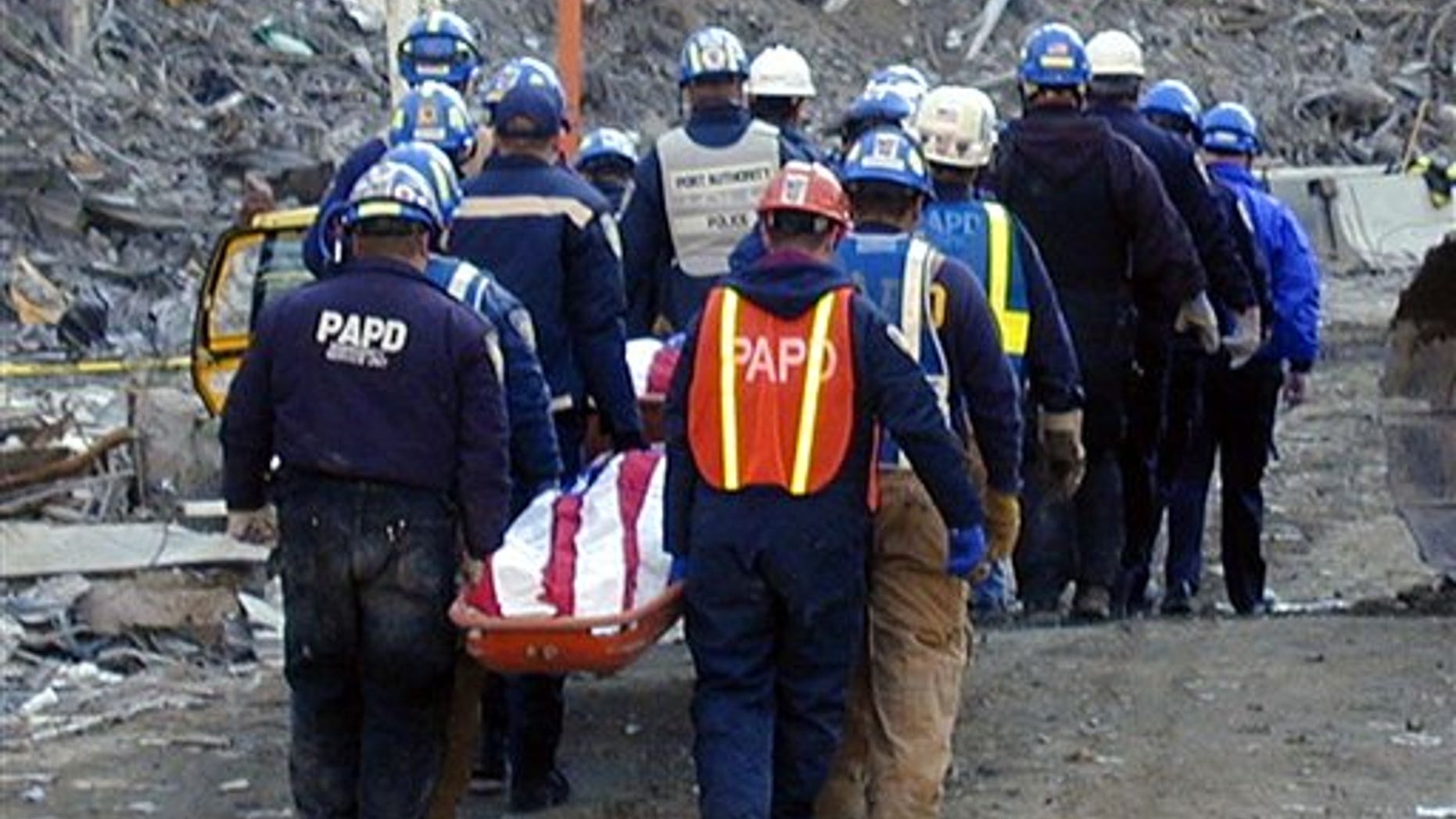 In this undated photo provided by Stony Brook University, New York City police and firefighters remove the body of a victim during recovery efforts at the World Trade Center in New York in the aftermath of the Sept. 11, 2011 attacks on the trade center.