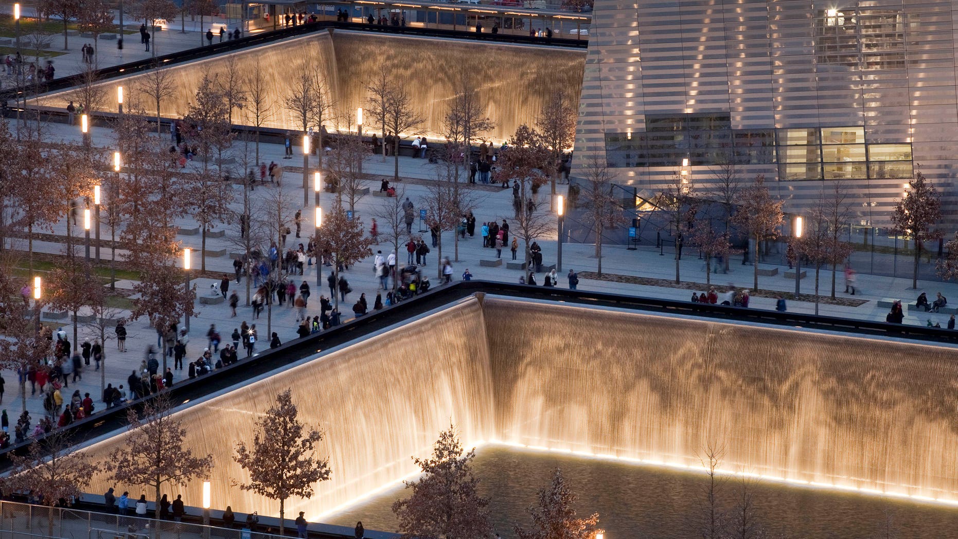 FILE - In this Dec. 20, 2011 file photo, visitors to the National September 11 Memorial in New York walk around its twin pools. The foundation that runs the memorial estimates that once the roughly $700 million project is complete, it will cost $60 million a year to operate. (AP Photo/Mark Lennihan, File)
