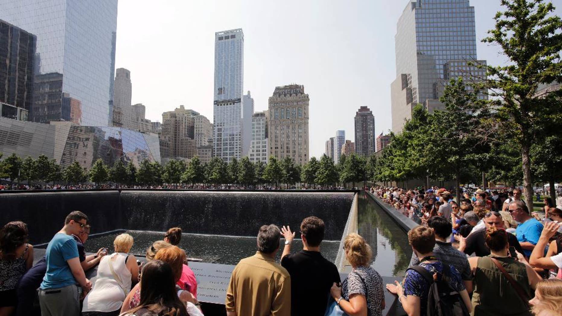 FILE - In this Aug. 8, 2014 file photo, visitors to the Sept. 11 memorial view one of the two reflecting pools in New York. A tourist from Texas was arrested on Saturday Aug. 1, 2015 on charges she was packing two loaded handguns at the Sept. 11 memorial in New York City, authorities said. According to a criminal complaint, Elizabeth Enderli was visiting the site when she informed a police officer she had the weapons in her backpack. She was charged with criminal possession of a weapon before being released Sunday. Acording to friends, the 31-year-old military veteran has a permit to carry weapons in her home state and mistakenly believed the permit covered her visit to New York from the Houston area. (AP Photo/Mark Lennihan, File)