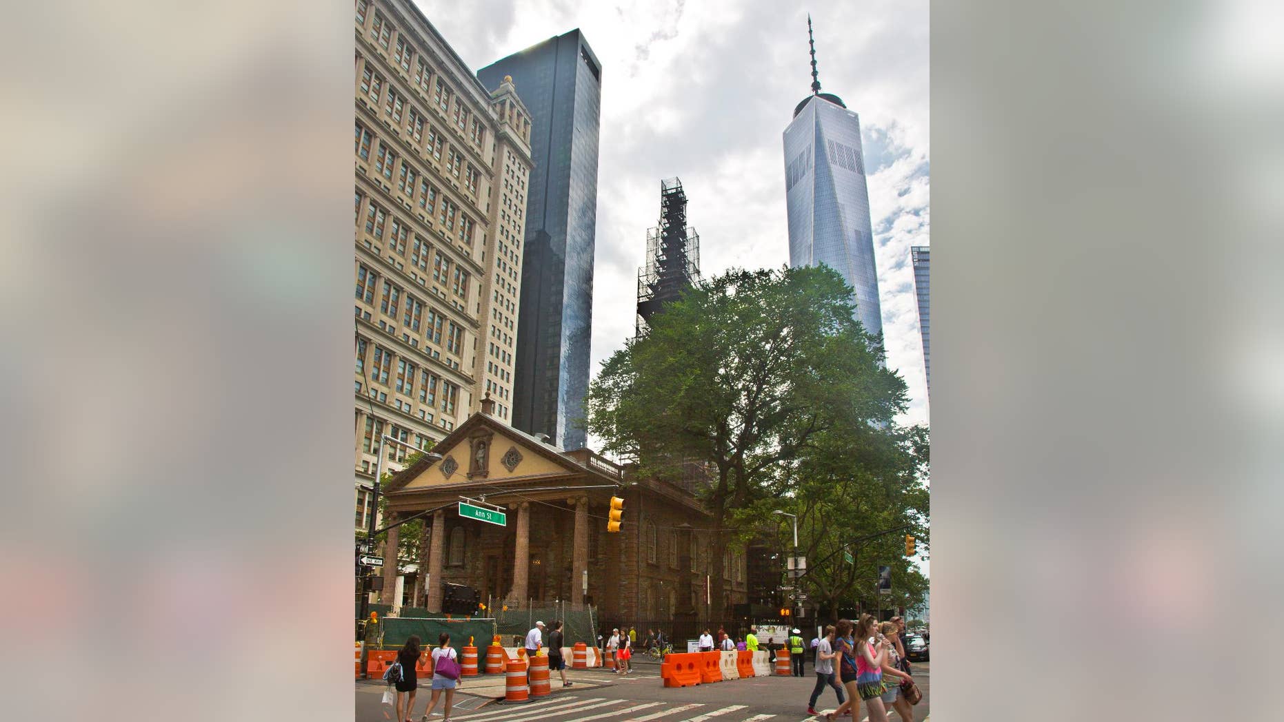 FILE - In this June 25, 2015, file photo, the World Trade Center, right, looms behind St. Paul's Chapel with its steeple wrapped in scaffolding for repairs, in New York. The winner of a new competition open to people of all faiths called "The Reconciliation Preaching Prize," has been won by an Army chaplain from Austin, Texas. The Rev. David Peters will have the privilege of delivering an original sermon on Sept. 11, at the chapel near ground zero that was turned into a makeshift memorial shrine and became a place of rest and renewal for volunteers and responders, following the terrorist attacks that brought down the twin towers. (AP Photo/Bebeto Matthews, File)