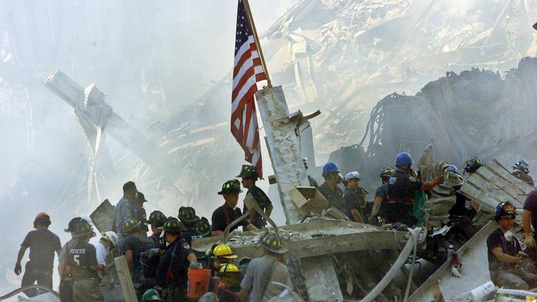FILE - In this Sept. 13, 2001 file photo, an American flag flies over the rubble of the collapsed World Trade Center buildings in New York. For years, a handful of current and former American officials have been urging President Barrack Obama to release secret files that they believe document links between the government of Saudi Arabia and the terrorist attacks of September 11, 2001. Other officials, including the executive director of the 9-11 commission, have said the classified documents don’t prove that the Saudi government knew about or financed the attacks_and that making them public would fuel bogus conspiracy theories. (AP Photo/Beth A. Keiser, File)