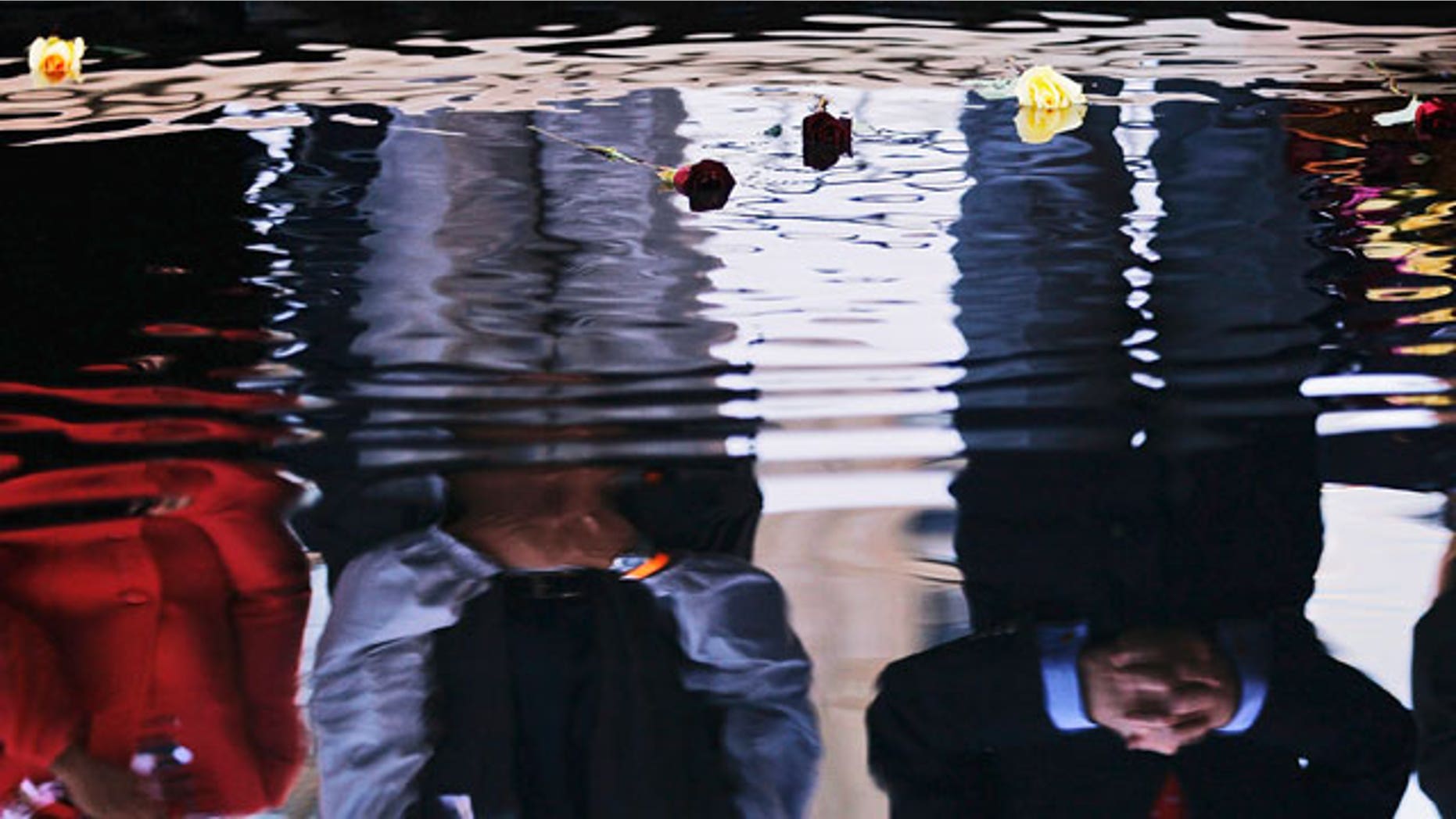 Flowers float in a reflecting pool in memory of victims of the Sept. 11 terrorist attacks after politicians dropped them into the water during the ninth anniversary of the attacks at the World Trade Center Saturday, Sept. 11, 2010 in New York.