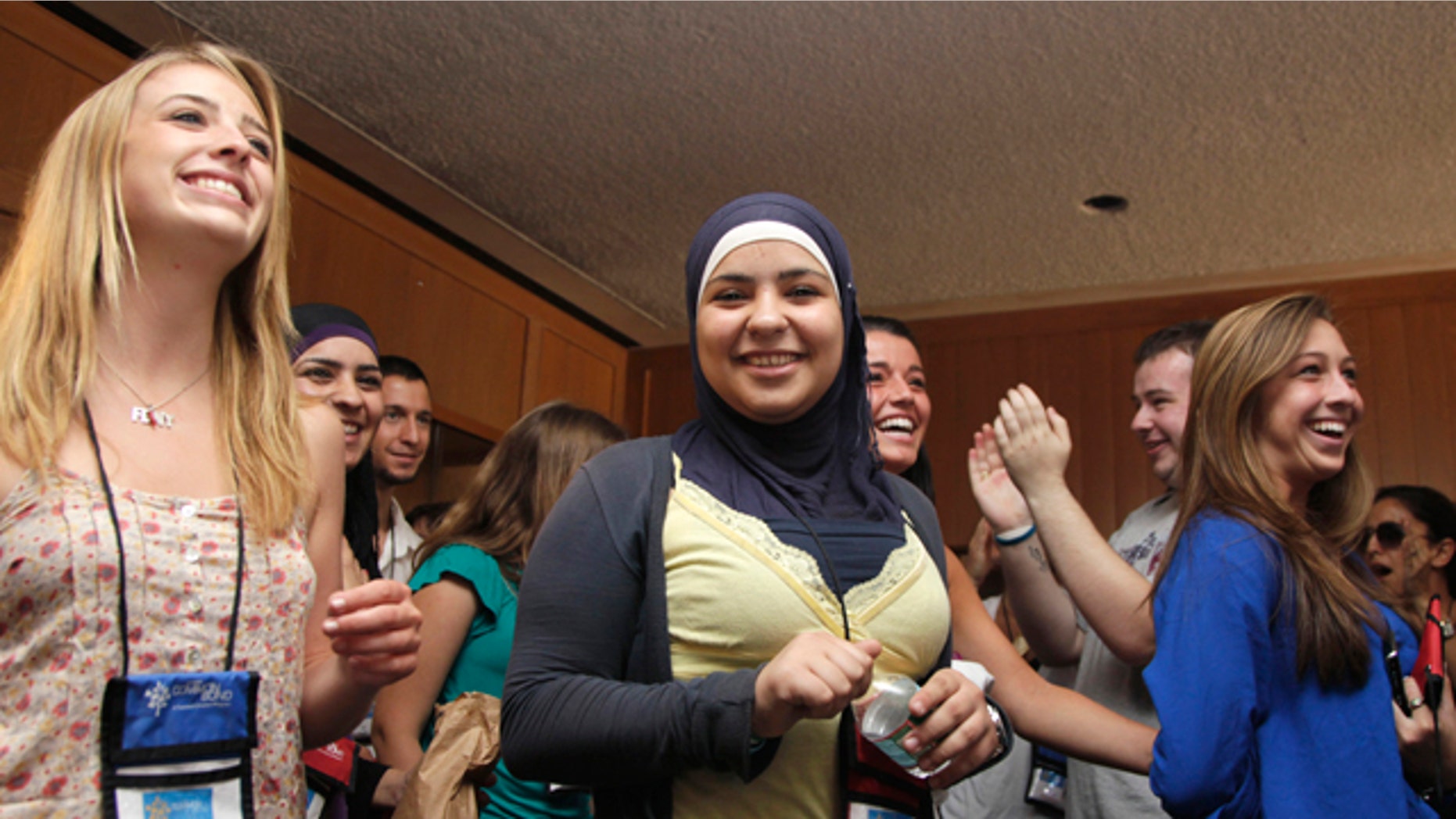 July 27: From left, Caitlin Leavey, of New York, Farrah Sarrawi of Palestine, Francesca Picerno of the US, and Allison Stahlman, are applauded during Project Common Bond on the Foxcroft School campus in Middleburg, Va. Project Common Bond brings together offspring of 9/11 victims with other teens who have lost family members to acts of terror around the world.