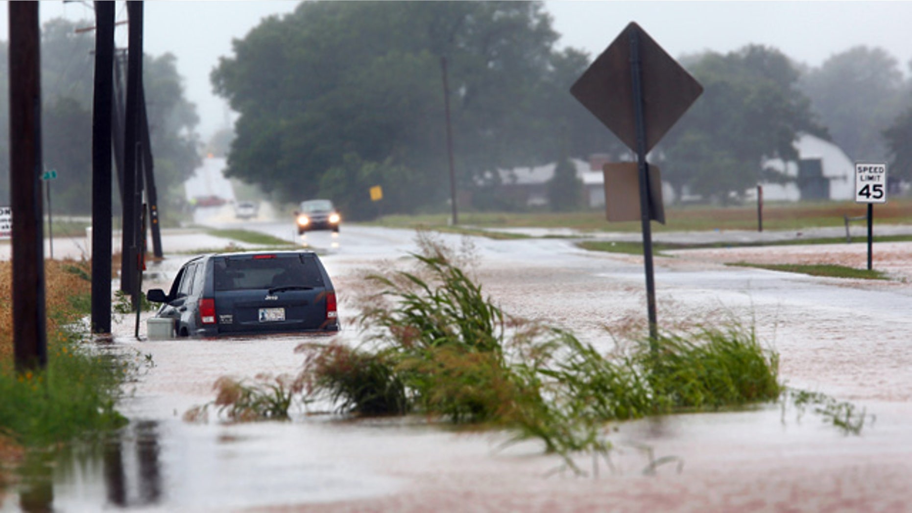 June 18, 2015: A vehicle is pointed the wrong direction after high water pushed it into a ditch on the south side of Hardesty Road west of US 177 in Shawnee, Okla. (Jim Beckel/The Oklahoman via AP)