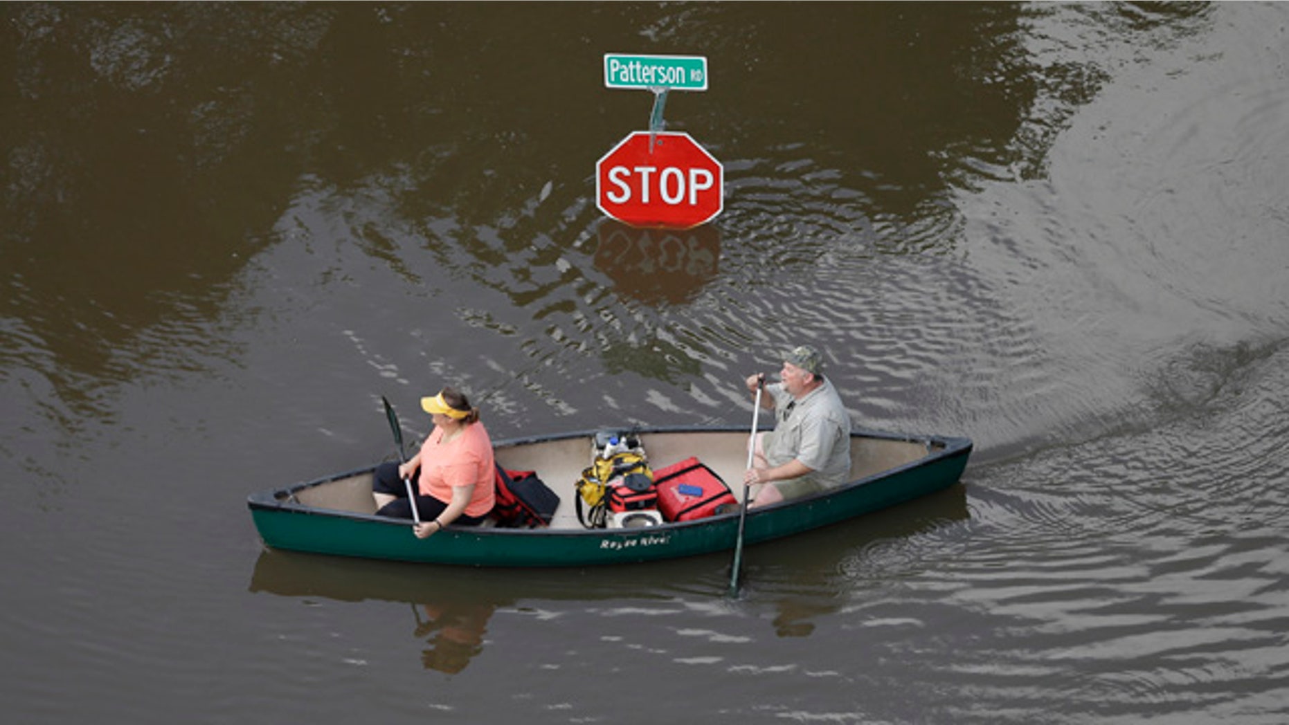 May 30, 2015: In this aerial photo, people canoe through floodwaters past a stop sign near Bear Creek Park in Houston. (AP Photo/David J. Phillip)