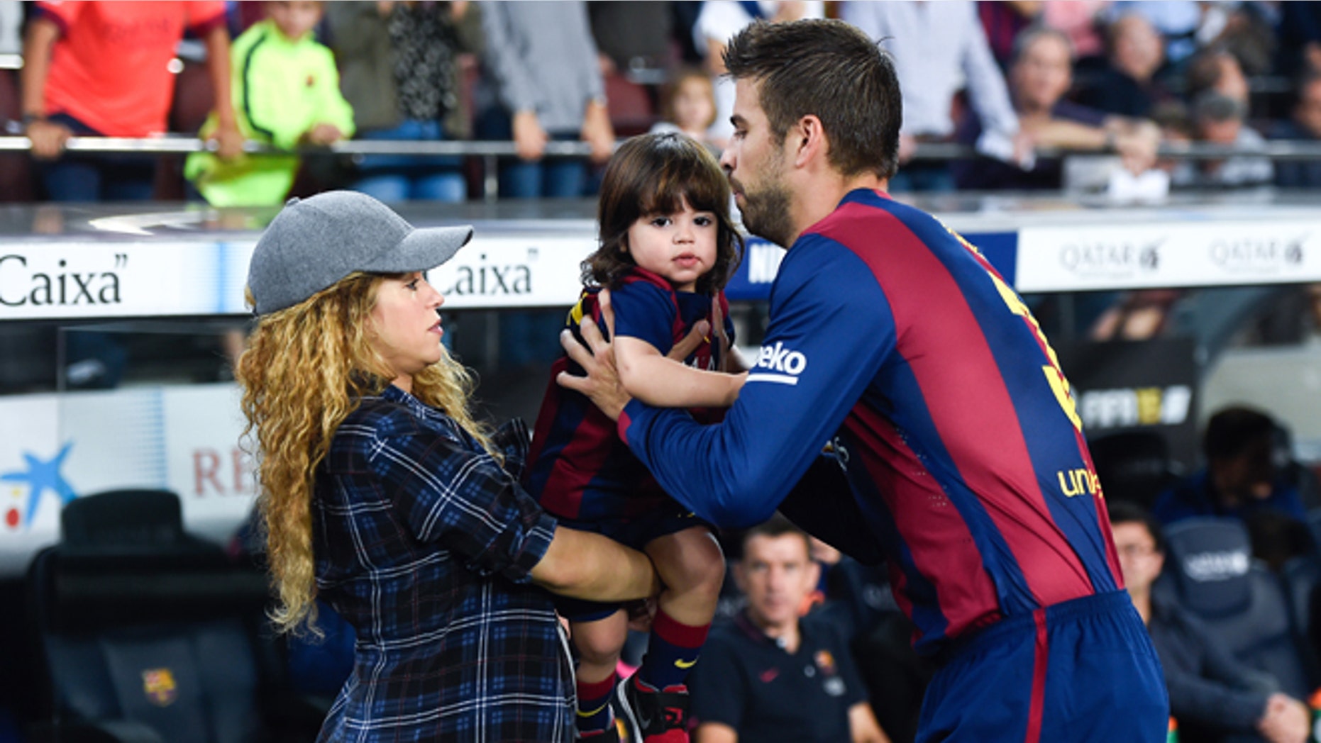 BARCELONA, SPAIN - OCTOBER 18: Gerard Pique of FC Barcelona passes his son Milan to his wife Shakira during the La Liga match between FC Barcelona and SD Eibar at Camp Nou on October 18, 2014 in Barcelona, Spain. (Photo by David Ramos/Getty Images)