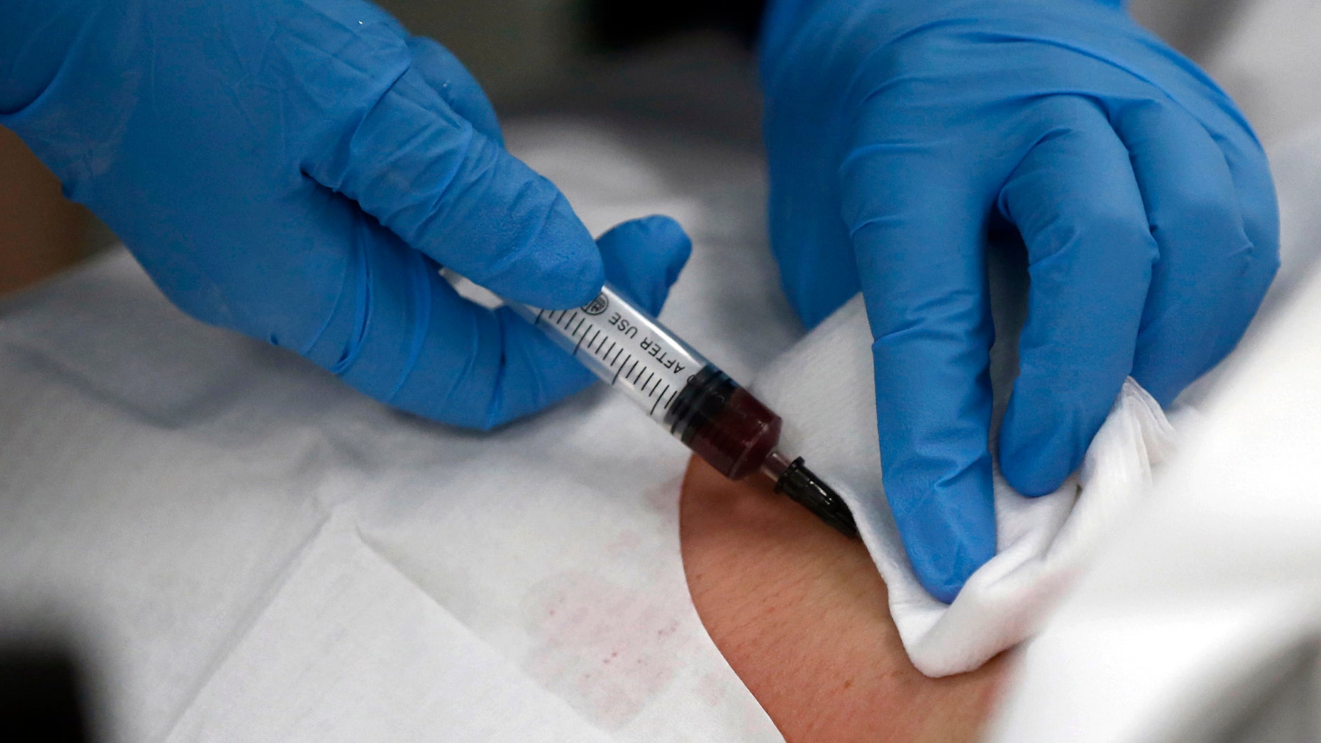 A doctor draws blood from the neck of a patient at an emergency room of a hospital in Shanghai May 15, 2013. To match CHINA-HOSPITALS/BRIBERY Picture taken May 15, 2013. REUTERS/Aly Song (CHINA - Tags: HEALTH CRIME LAW BUSINESS) - RTX11WJN
