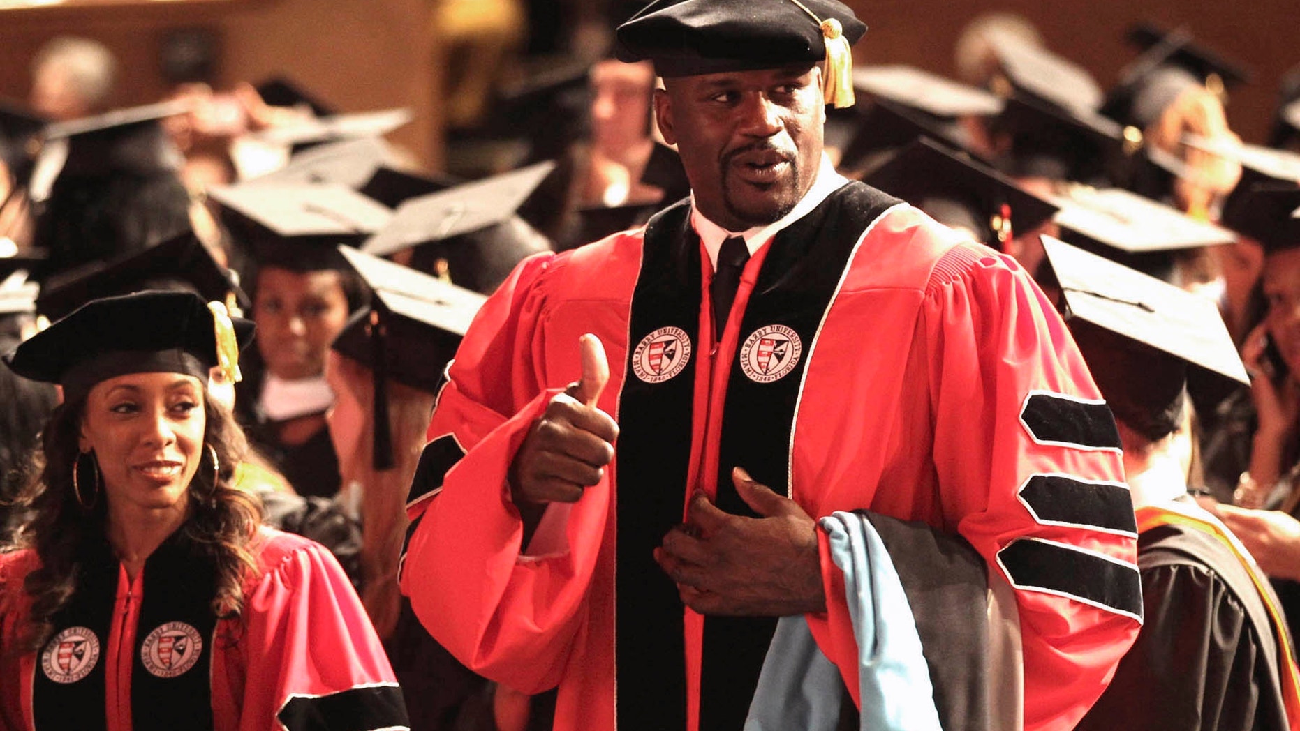 May 5, 2012: Towering over his classmates, former NBA star Shaquille O'Neal, gestures before the graduation ceremony at the James L. Knight Center in Miami.