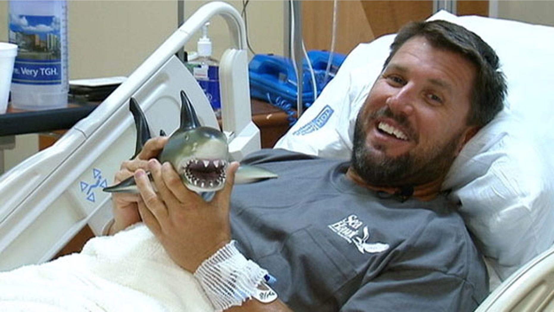 Shark bite survivor Erik Norrie plays with a toy shark a friend got him as a joke.