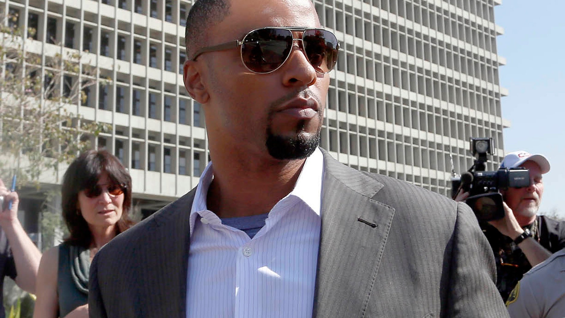 Feb. 14, 2014: Former NFL safety Darren Sharper leaves a courthouse in Los Angeles. An arrest warrant has been issued for Sharper and another man, accusing them of raping two women in New Orleans last year. Sharper also is under investigation in sexual assault cases in Florida, Nevada and Arizona and has pleaded not guilty to rape charges in Los Angeles. (AP/Nick Ut )