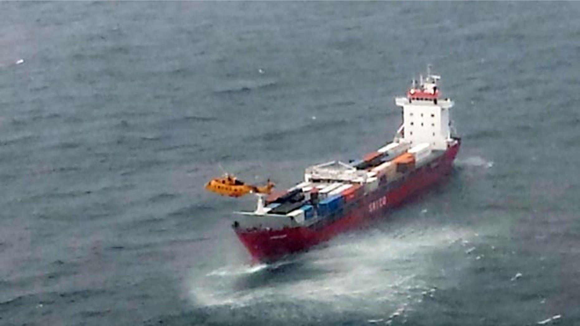 October 17, 2014: In this aerial photo provided by the Department of National Defense Maritime Forces Pacific, a Canadian Coast Guard helicopter flies near a Russian container ship carrying hundreds of tons of fuel drifting without power in rough seas off British Columbia's northern coast. (AP Photo/The Canadian Press, Department of National Defense Maritime Forces Pacific)