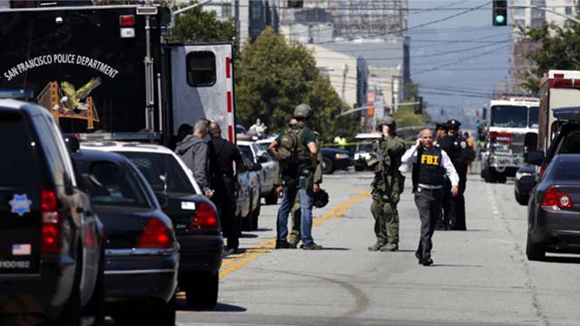 July 12, 2013: San Francisco Police officers and FBI officials work the scene near at Eighth Street and Brannan Street after a shooting. Two women were killed and a man was wounded on Friday before a suspect covered in blood was arrested at a shopping center in a crowded San Francisco neighborhood that is home to police headquarters and several tech companies (AP Photo/San Francisco Chronicle, Katie Meek)