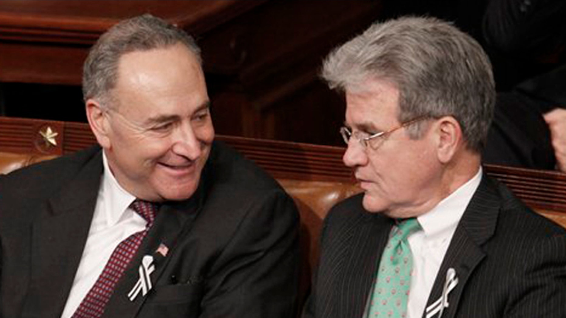 Sen, Charles Schumer, D-N.Y., left, talks with Sen. Tom Coburn, R-Okla., on Capitol Hill in Washington, during President Barack Obama's State of the Union address in Washington.