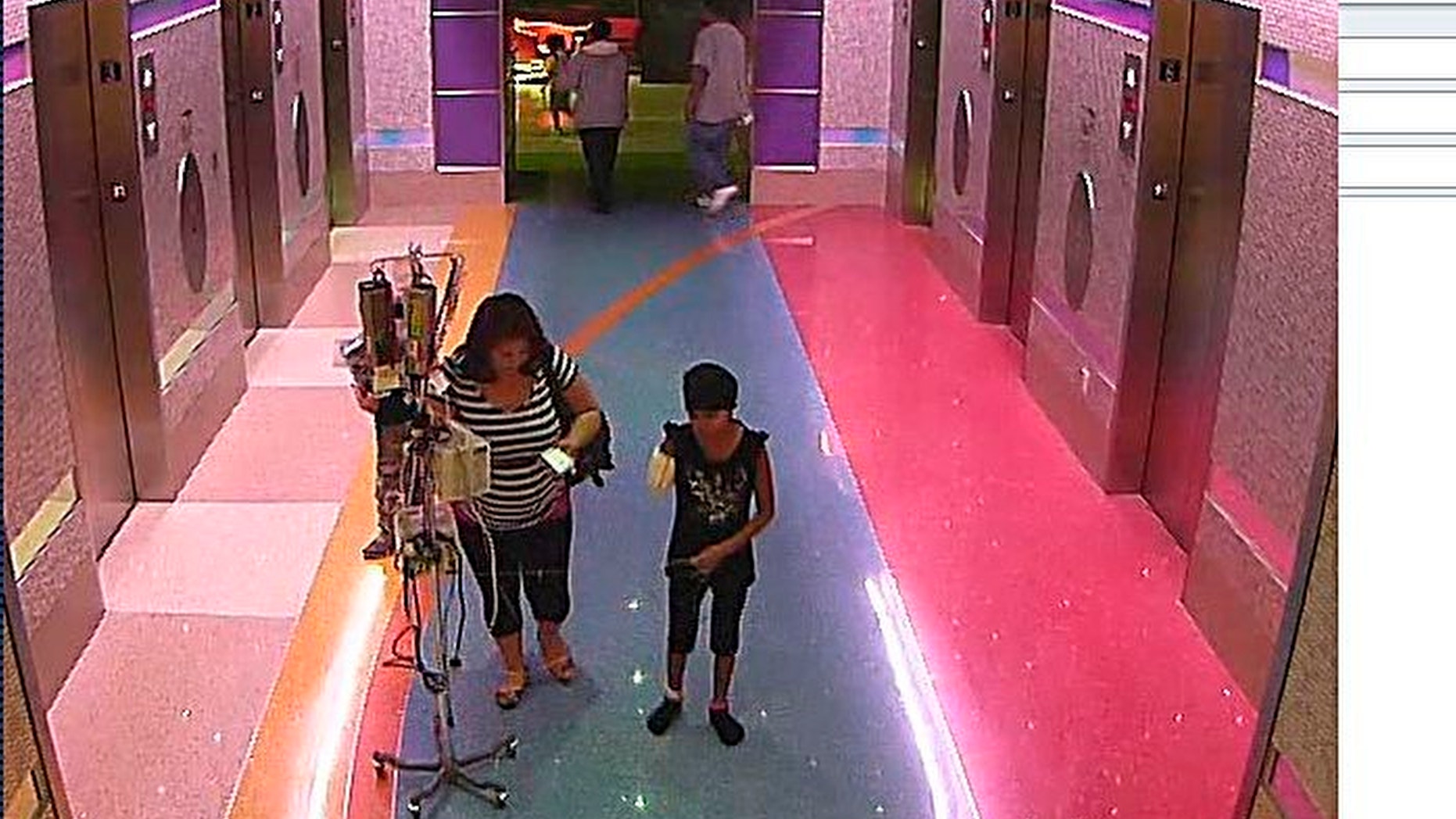 Dec. 3, 2012: In this hospital surveillance photo released by the Phoenix Police Department, a woman is seen with her 11-year-old daughter, a leukemia patient who had her arm amputated and a heart catheter inserted due to an infection.