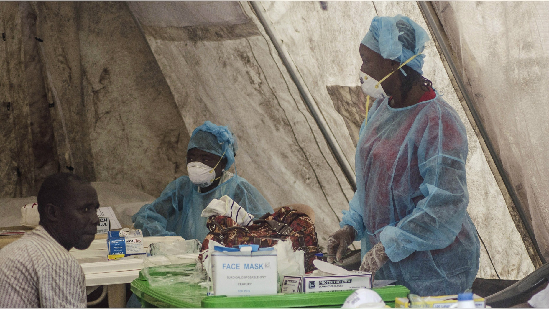 Health workers take blood samples for Ebola virus testing at a screening tent in the local government hospital in Kenema, Sierra Leone.