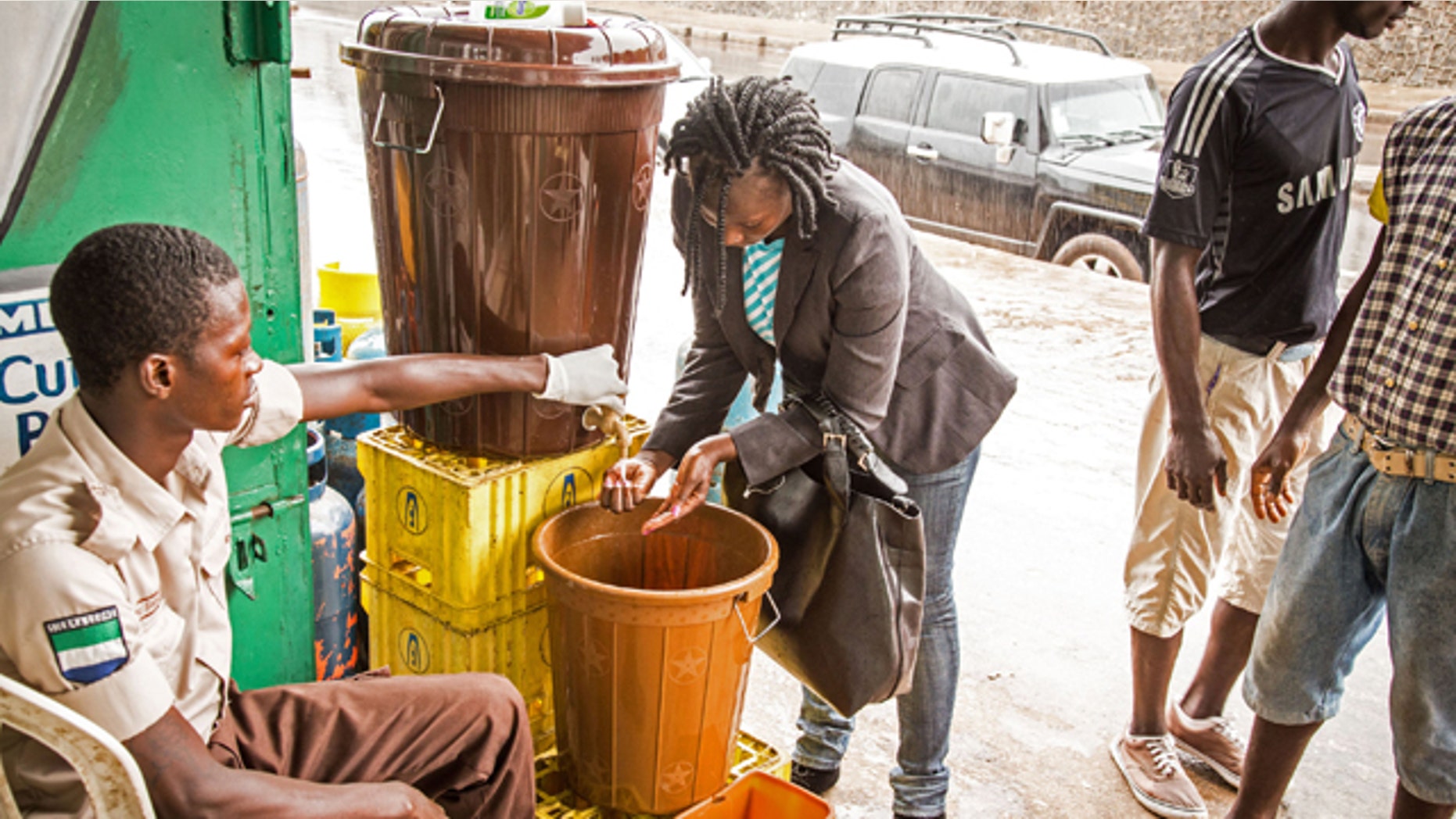 August 6, 2014: A woman washes her hands before she is allowed to enter a building as part of a Ebola prevention campaign in the city of Freetown, Sierra Leone. The World Health Organization has begun an emergency meeting on the Ebola crisis, and said at least 932 deaths in four African countries are blamed on the virus, with many hundreds more being treated in quarantine conditions. (AP Photo/ Michael Duff)