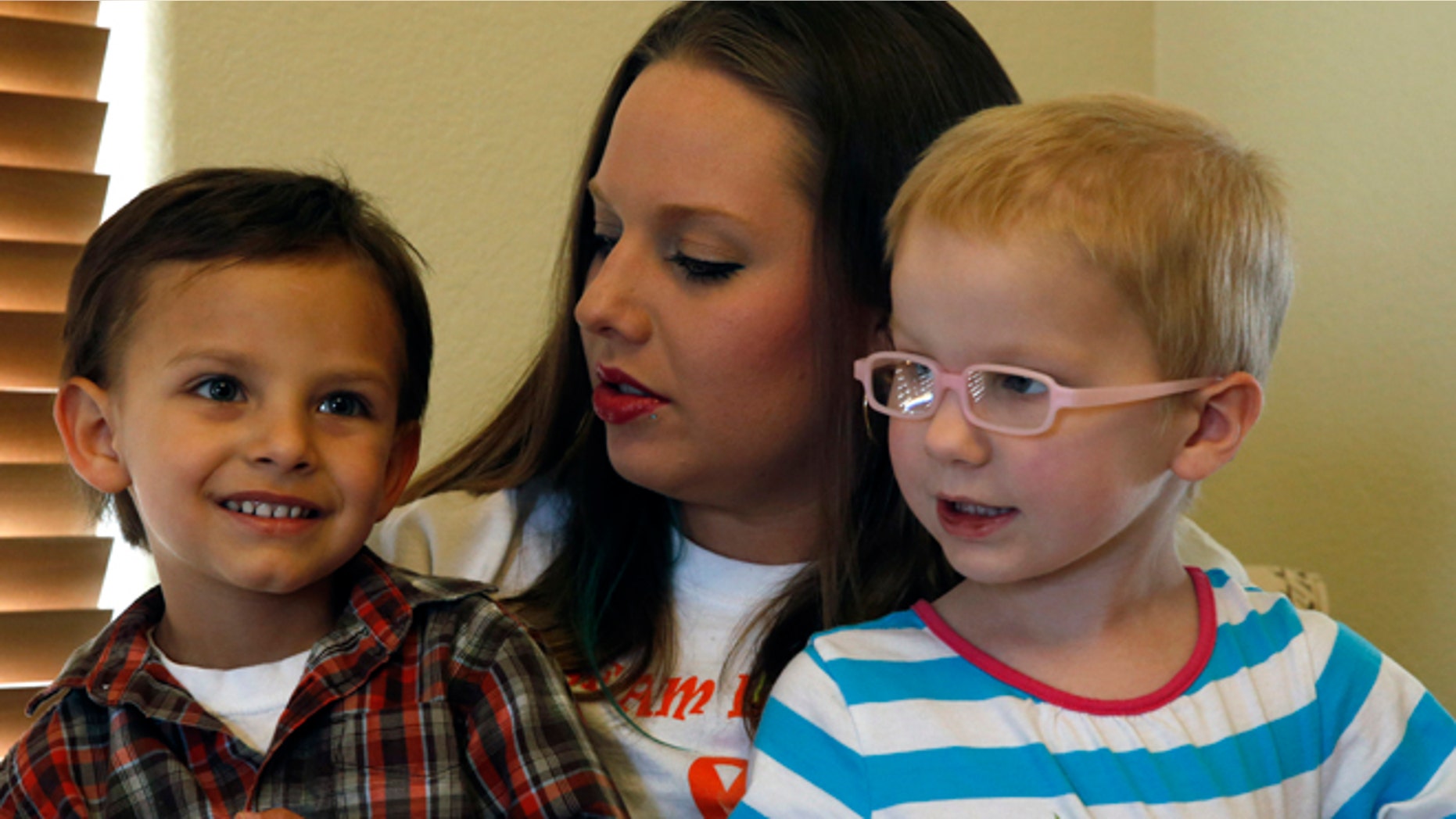 In this April 29, 2014 photo, mother of a child with cancer Sierra Riddle plays with her son Landon, age 4, left, and Landon's friend Dahlia, age 3, who also has cancer, during a play date at Dahlia's home in Colorado Springs. Landon and Dahlia's parents, frustrated with mainstream medical treatments and facing the possibility of intervention by child protective authorities, moved to Colorado to treat their children using what some describe as cutting edge cannabis medication. Hundreds of parents in similar situations find themselves at the center of a debate about how far government can and should reach when parents push against legal boundaries to save their childrens' lives.