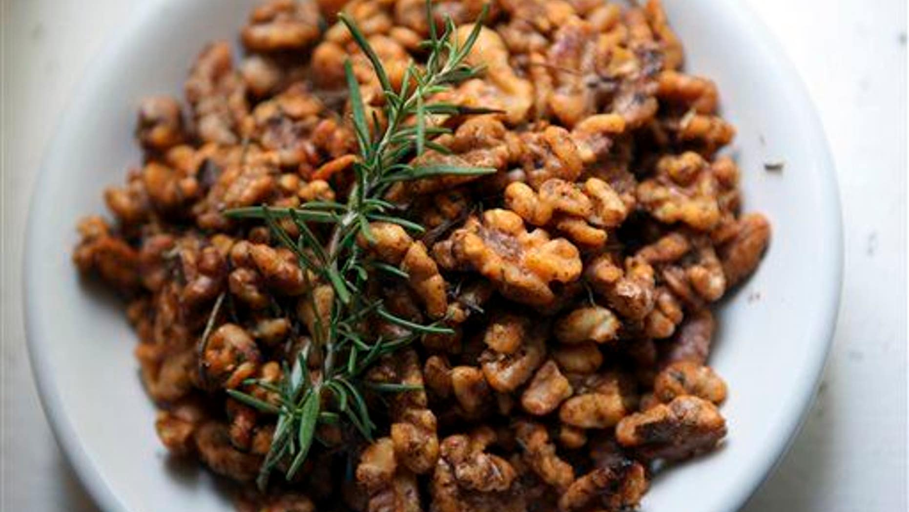 In this July 8, 2014 photo, a sprig of rosemary garnishes walnuts.