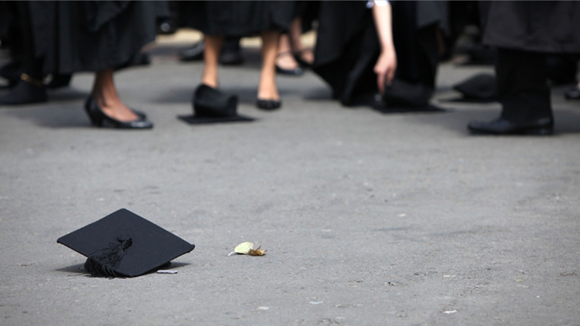 BIRMINGHAM, ENGLAND - JULY 14: Students pick up their mortarboards after the offical hat throwing photograph at the University of Birmingham on July 14, 2009 in Birmingham, England. Over 5000 graduates will be donning their robes this week to collect their degrees from The University of Birmingham. A recent survey suggested that there are 48 graduates competing for every job. (Photo by Christopher Furlong/Getty Images)