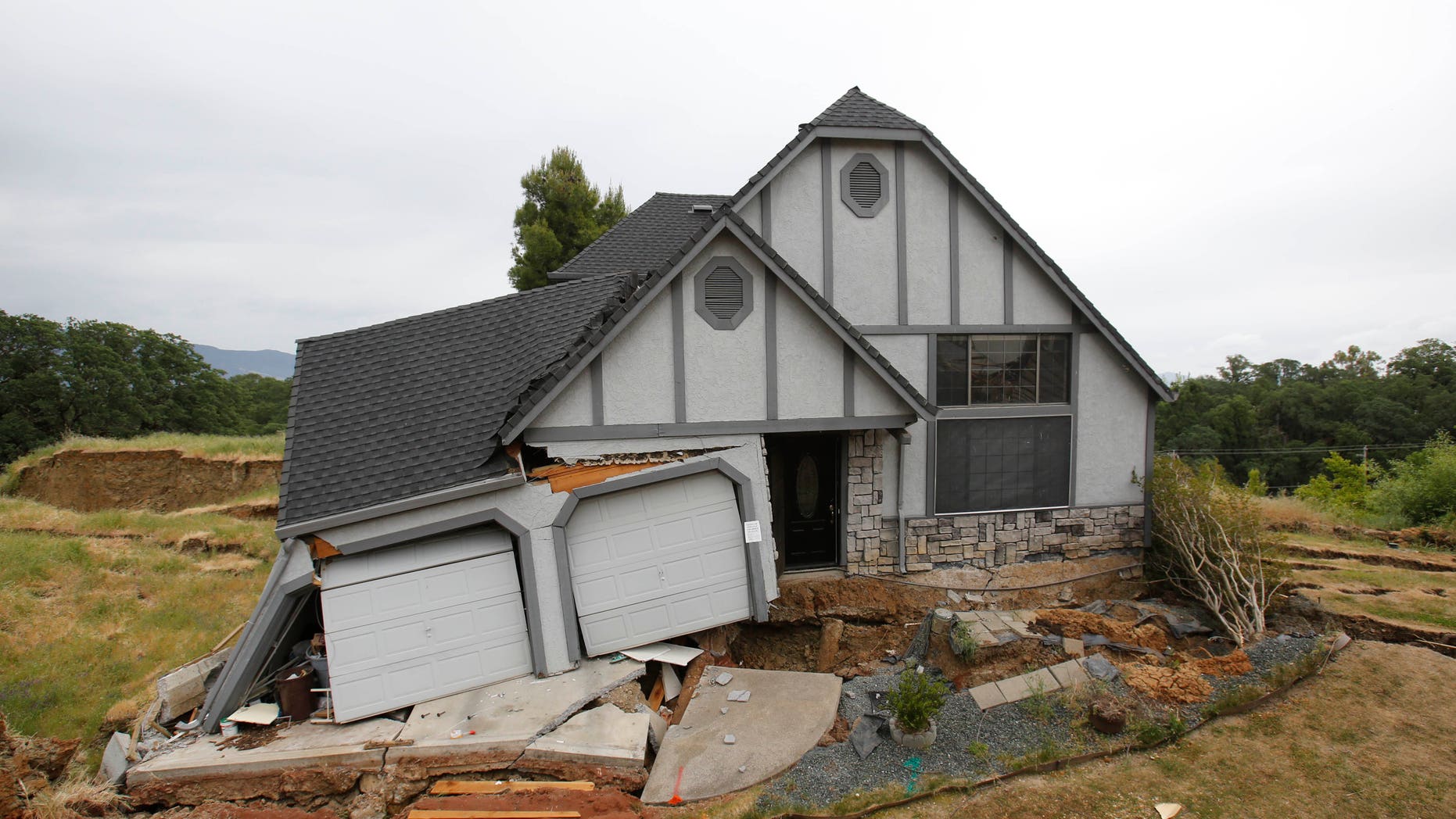 May 6, 2013: This photo shows the wreckage of the Tudor-style dream home of Robin and Scott Spivey who were forced to abandon after the ground gave way causing it to drop 10 feet below the street in Lakeport, Calif.