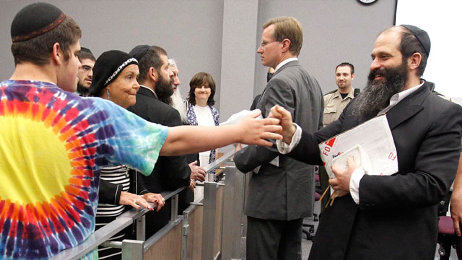 June 1: Moishe Rubashkin, 16, says hello to his father defendant Sholom Rubashkin, former Agriprocessors co-vice president, after his child labor trial ending early for lunch at the Black Hawk County Courthouse in Waterloo, Iowa. (AP)