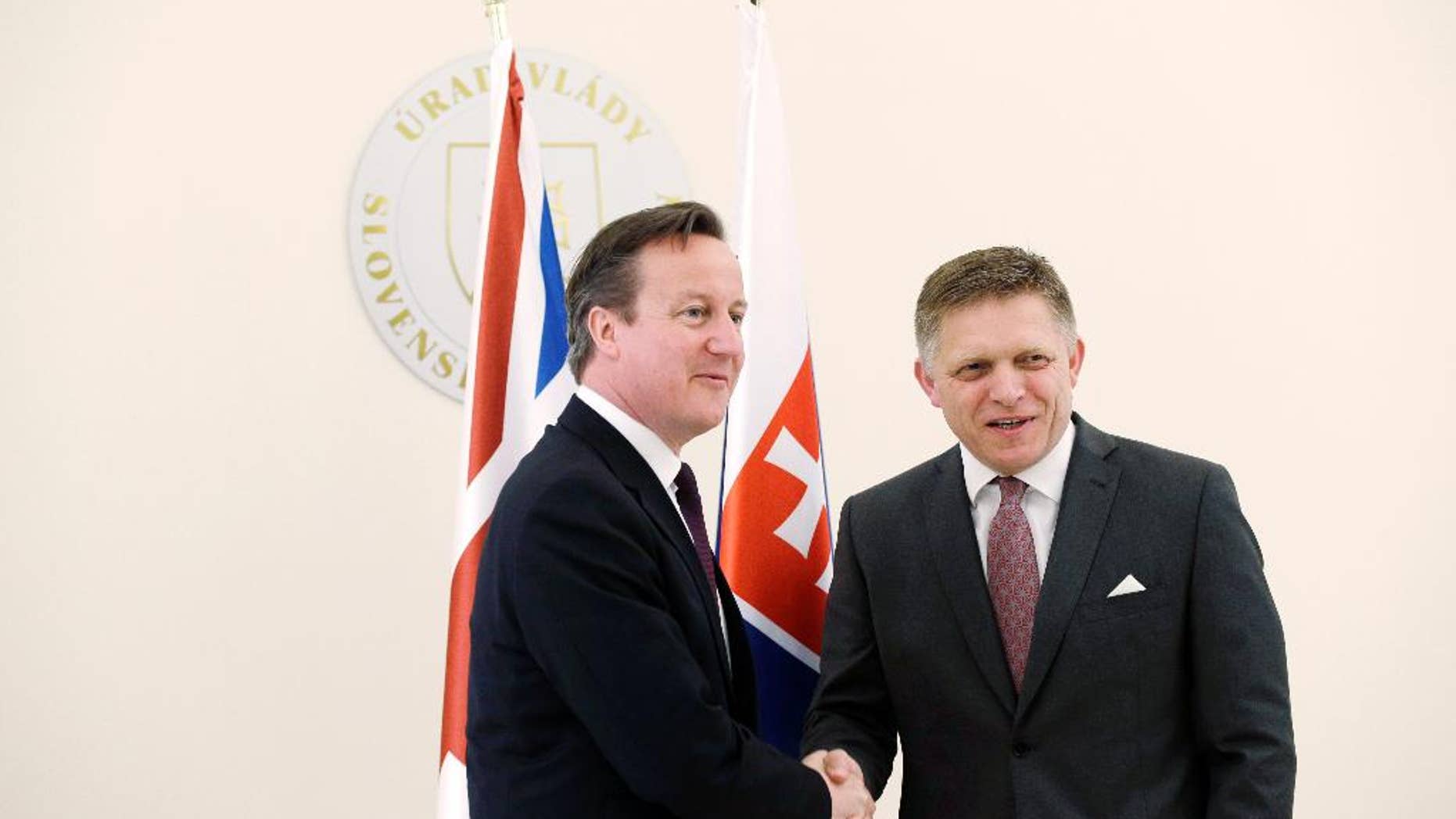 Slovakia's Prime Minister Robert Fico, right, welcomes British Prime Minister David Cameron, left, in Bratislava, Slovakia, Friday, June 19, 2015. (AP Photo/Petr David Josek)