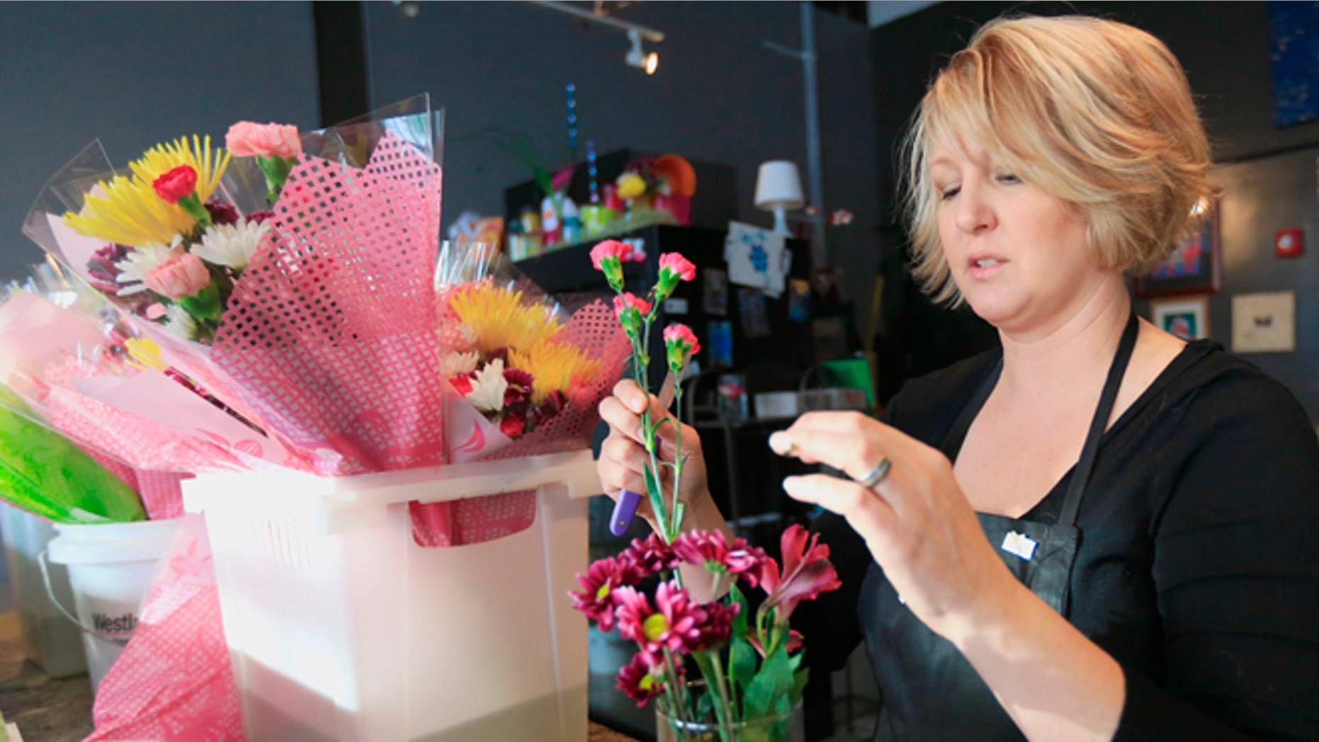 Rhonda Bullington, owner of Loess Hills Floral Studio in Council Bluffs, Iowa, makes a flower arrangement in Council Bluffs, Iowa, Friday, Feb. 6, 2015. The vast majority of cut flowers used in florists' bouquets are imported and Bullington says she hasn't had any customers asking for locally-grown flowers. (AP Photo/Nati Harnik)
