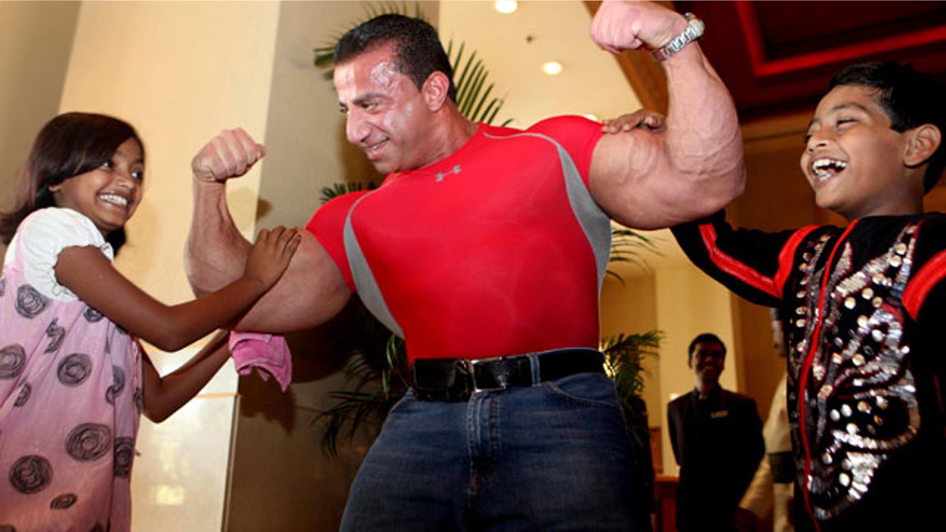 New York-based Lebanese body builder George Farah, center, poses with "Slumdog Millionaire" child stars Azharuddin Mohammed Ismail, right, and Rubina Ali when they happen to meet at a hotel in Mumbai, India.