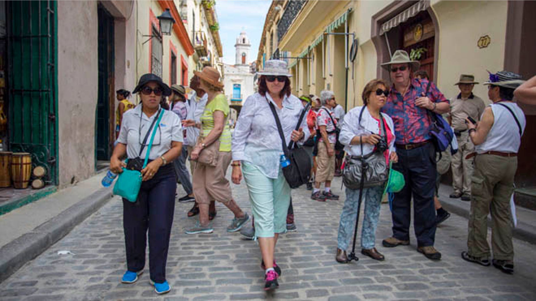In this Wednesday, April 20, 2016, photo, smarTours tour director Pamela Boudrot, center, and local tour guide Enedis Tamayo, left, lead a group of tourists in Havana. The thaw in U.S.-Cuba relations has many small and medium-sized companies thinking about doing business with the nation that has largely been off-limits for more than half a century. Greg Geronemus, owner of smarTours, based in New York, began planning to increase his Cuba business two years ago, when he ran 15 tours. He expects to run 45 tours to Cuba this year, most of them leaving from Miami. (AP Photo/Desmond Boylan)