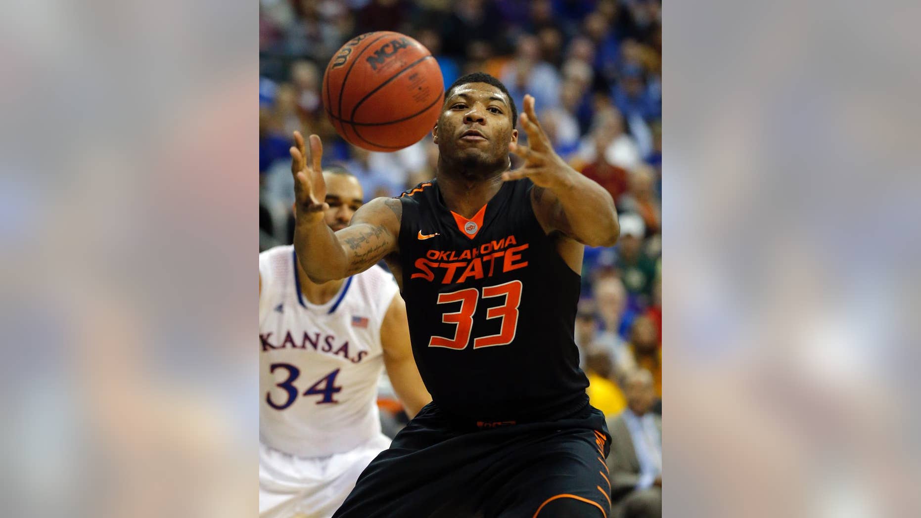 FILE - In this March 13, 2014 file photo, Oklahoma State guard Marcus Smart (33) reaches for the ball during the second half of an NCAA college basketball game against Kansas in the quarterfinals of the Big 12 Conference men's tournament in Kansas City, Mo. Oklahoma State (21-12), the No. 9 seed in the West Region, will play No. 8 seed Gonzaga (28-6) Friday, March 21, 2014, in San Diego in its NCAA tournament opener. This will be Smart’s last shot at tournament success because he will enter the NBA Draft after this season.(AP Photo/Orlin Wagner, File)