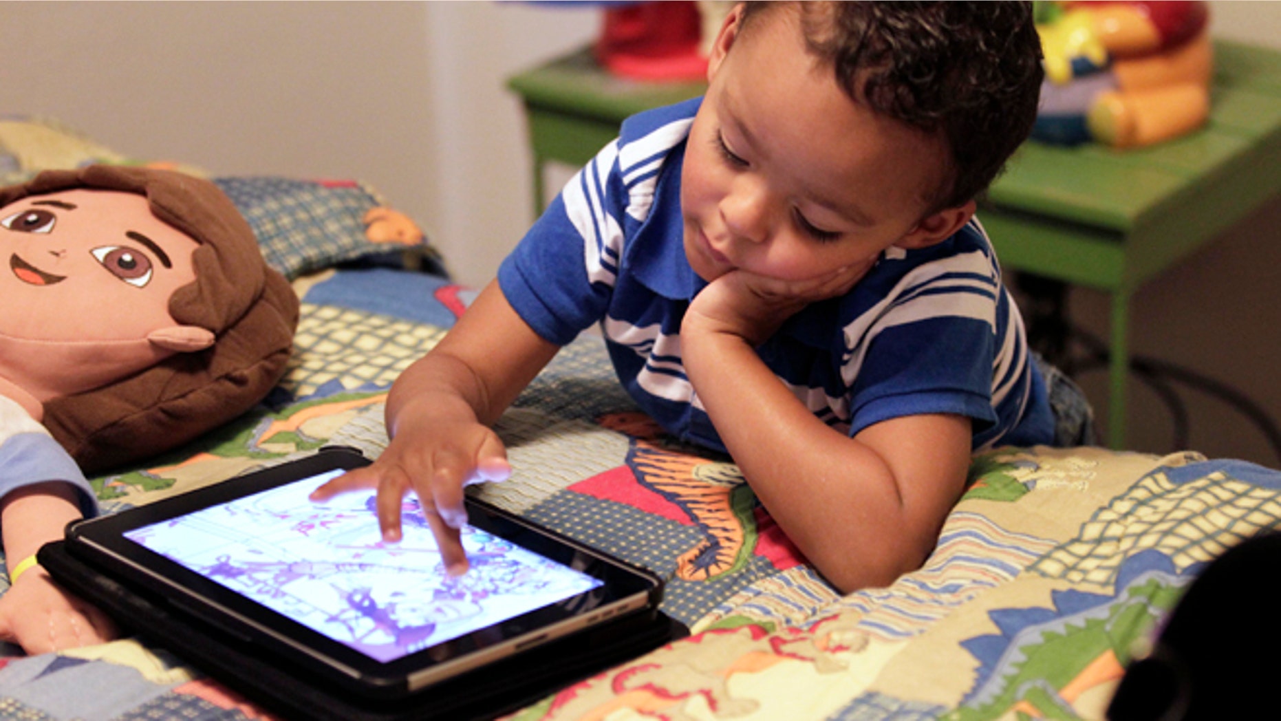 Frankie Thevenot, 3, plays with an iPad in his bedroom at his home in Metairie, La. As of Wednesday, Aug. 7, 2013, the Campaign for a Commercial-Free Childhood, is urging federal investigators to examine the marketing practices of Fisher-Price's and Open Solution's mobile apps. It's the campaign's first complaint against the mobile app industry.