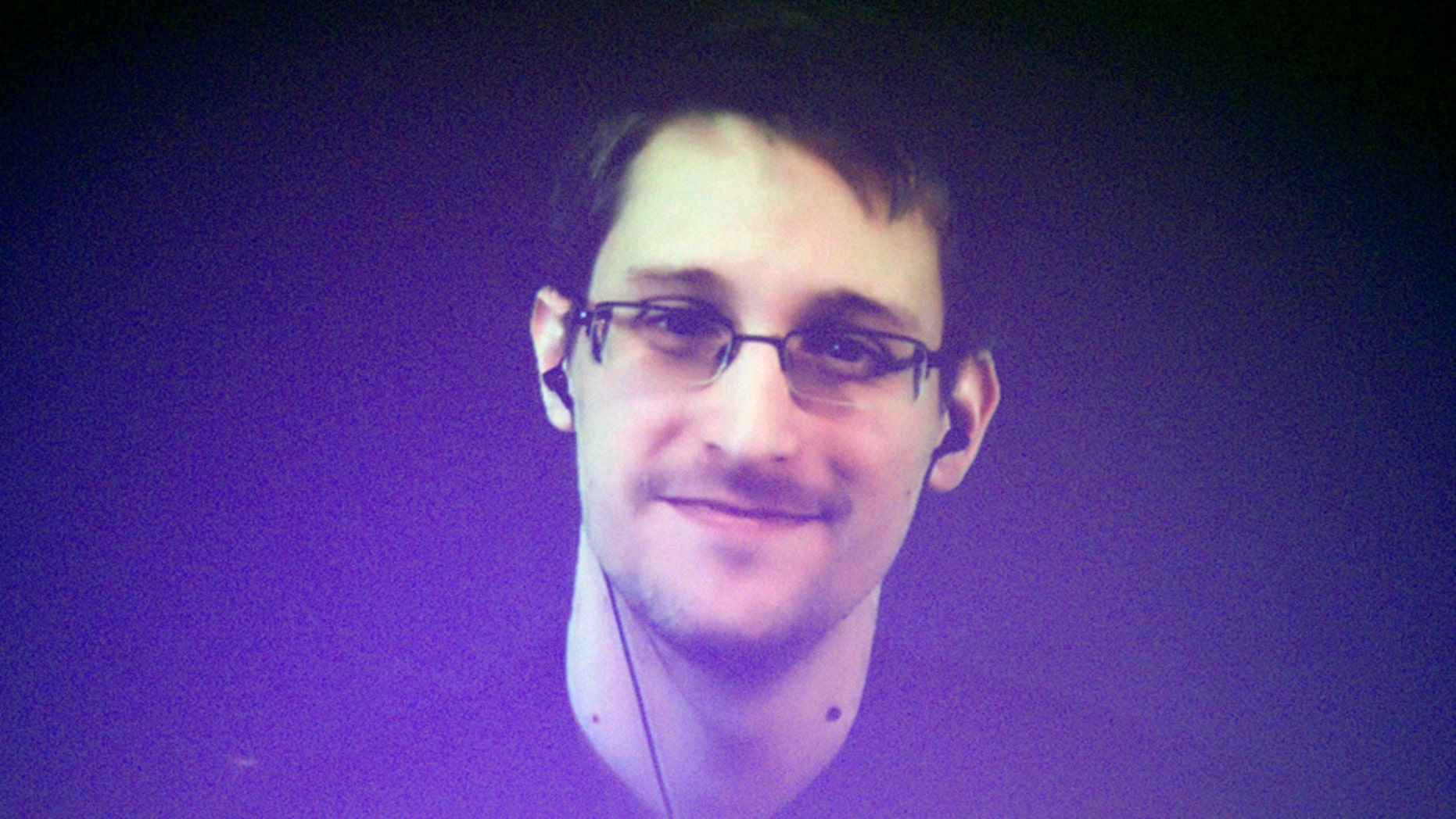 Edward Snowden, who is in Moscow, is seen on a giant screen during a live video conference for an interview as part of Amnesty International's annual Write for Rights campaign at the Gaite Lyrique in Paris Dec. 10, 2014.