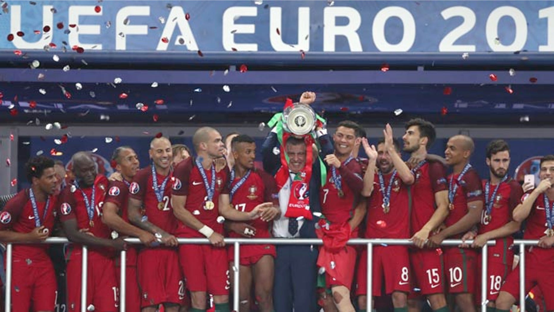 Portugal coach Fernando Santos lifts the trophy between Cristiano Ronaldo, Sunday, July 10, 2016.