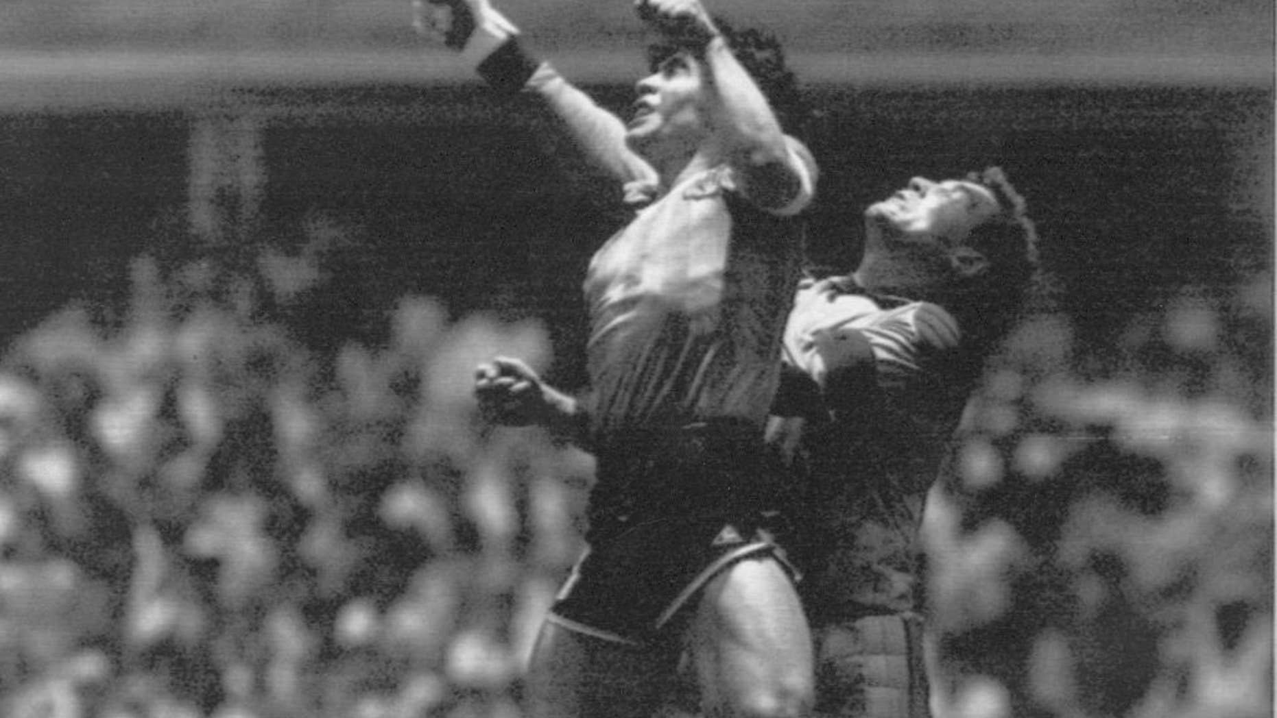 FILE - In this June 22, 1986 file photo Argentina's Diego Maradona, left, beats England goalkeeper Peter Shilton to a high ball and scores his first of two goals in a World Cup quarterfinal soccer match, in Mexico City. On this day: This was the day of the “Hand of God,” when Maradona used his left fist to knock a ball past England's Shilton. (AP Photo/El Grafico, Buenos Aires, File)